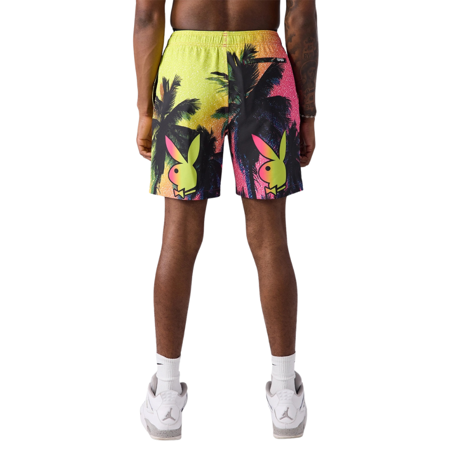 Person wearing colorful shorts with palm tree design on a white background