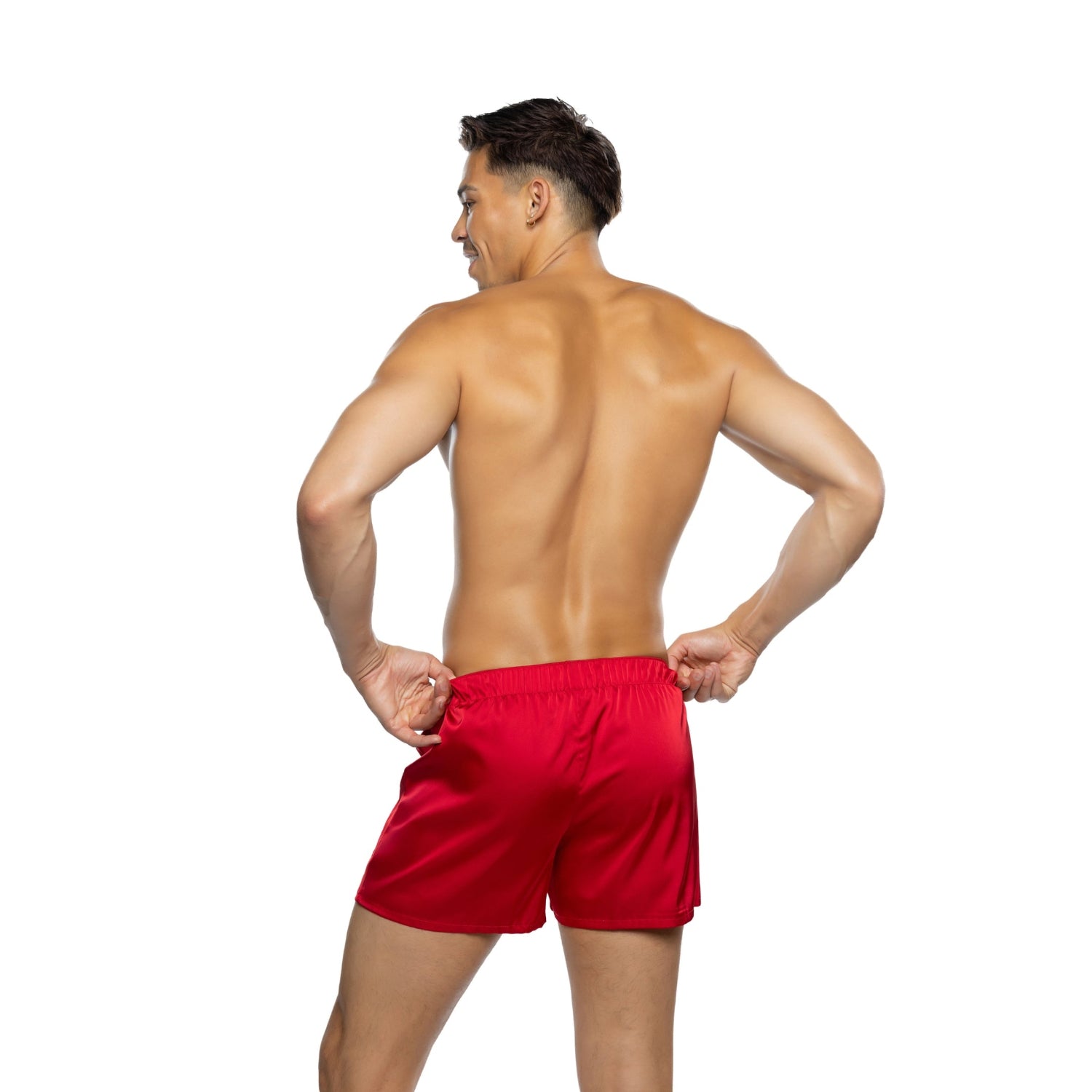 Shirtless man modeling red satin lounge shorts, back view, on white background