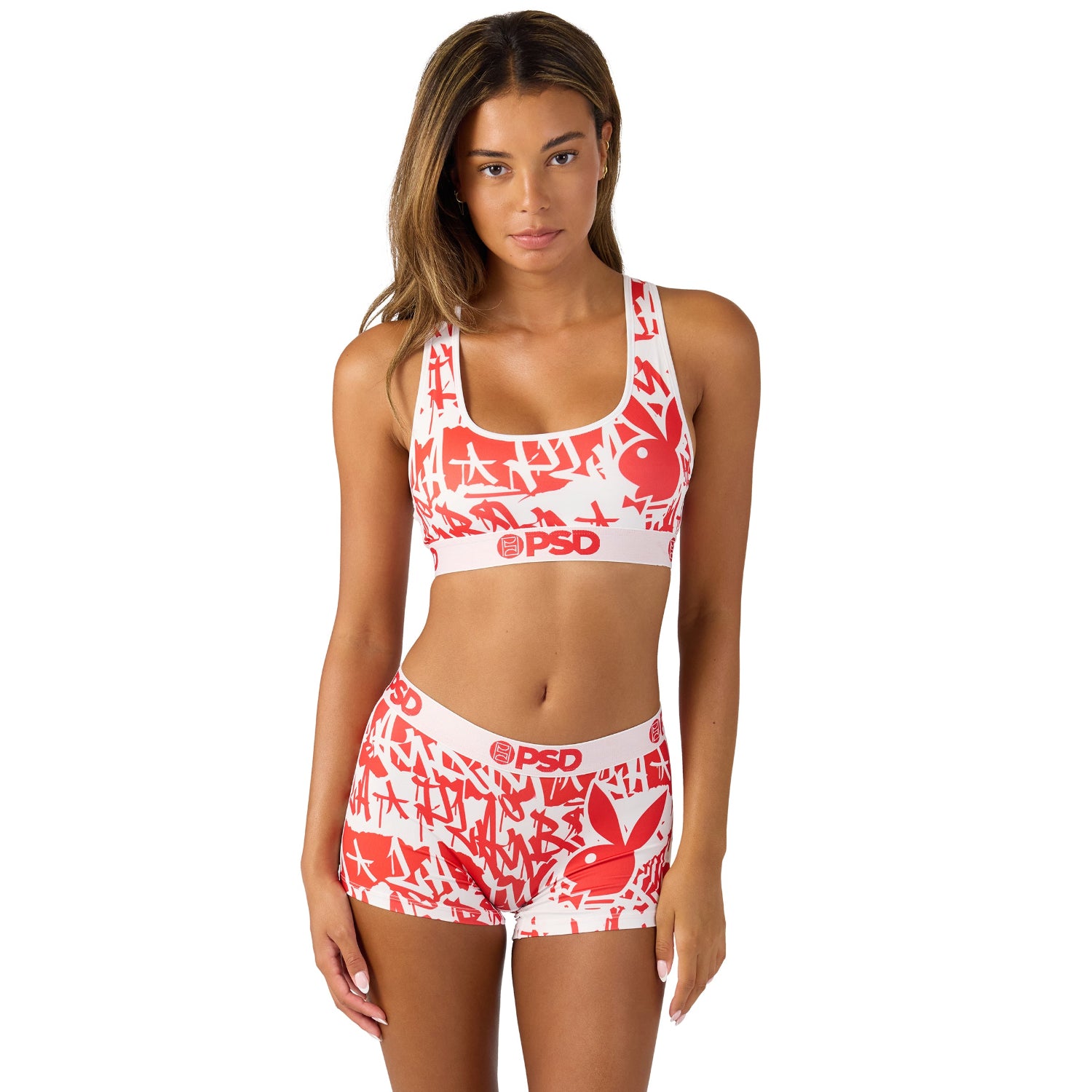 Woman wearing red and white graphic sports bra and shorts set with bold logo print