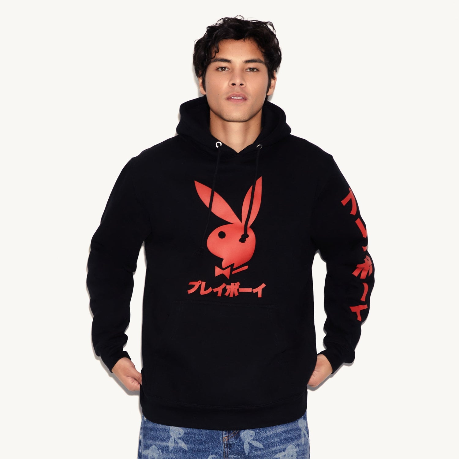 Person wearing a black hoodie with a red logo on a white background