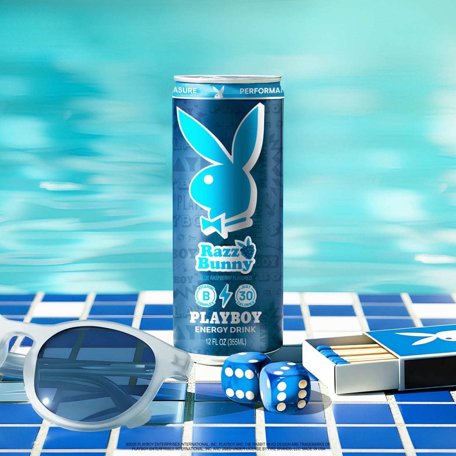 Playboy Razzle Bunny energy drink can with sunglasses, dice, and matches on a poolside table.