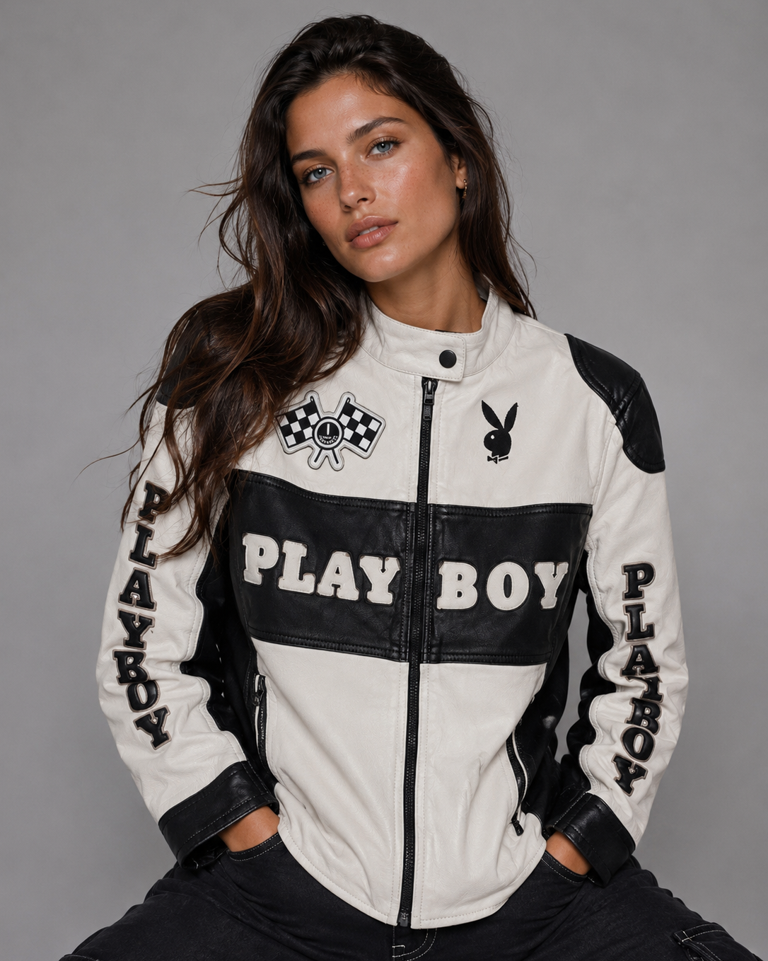 A woman wearing a white and black leather-look motorcycle jacket with 'PLAY BOY' text and the Playboy bunny logo, posed against a plain gray studio background. #Women