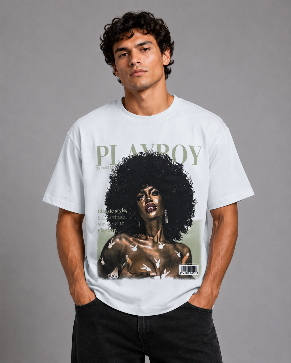 A man wearing a white Playboy t-shirt with a vintage magazine cover graphic, posed against a solid gray studio background.