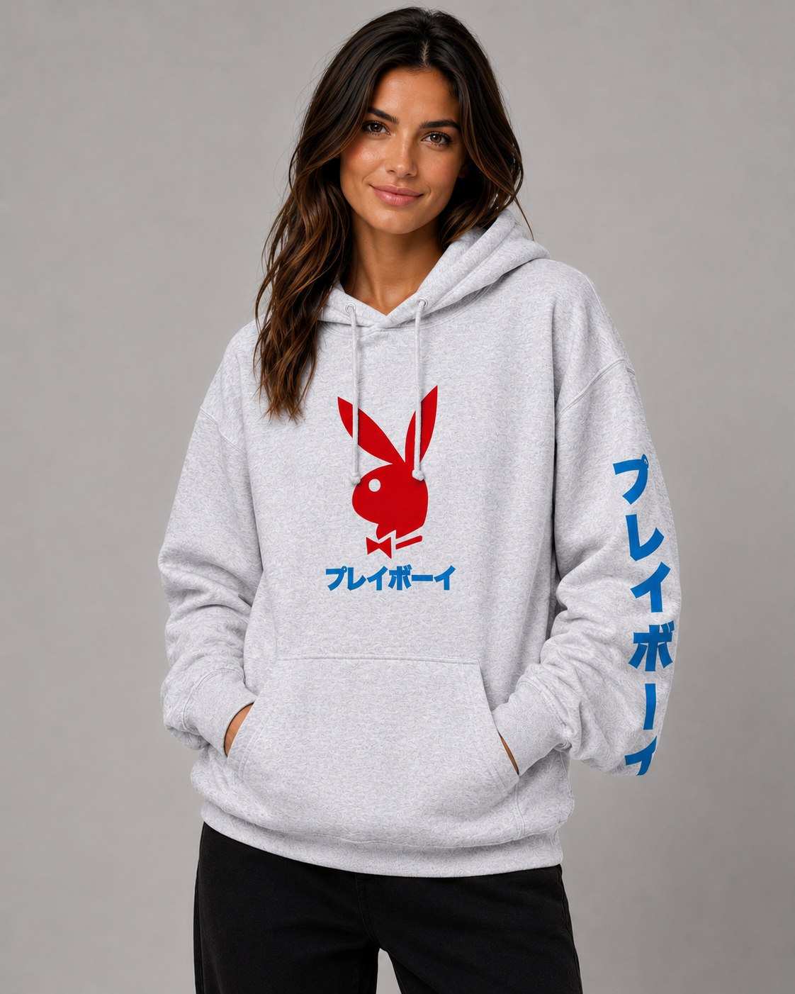 A woman wearing a light gray heather pullover hoodie with a red Playboy bunny logo and blue Japanese text on the front and sleeve, photographed against a plain gray studio background. #Women