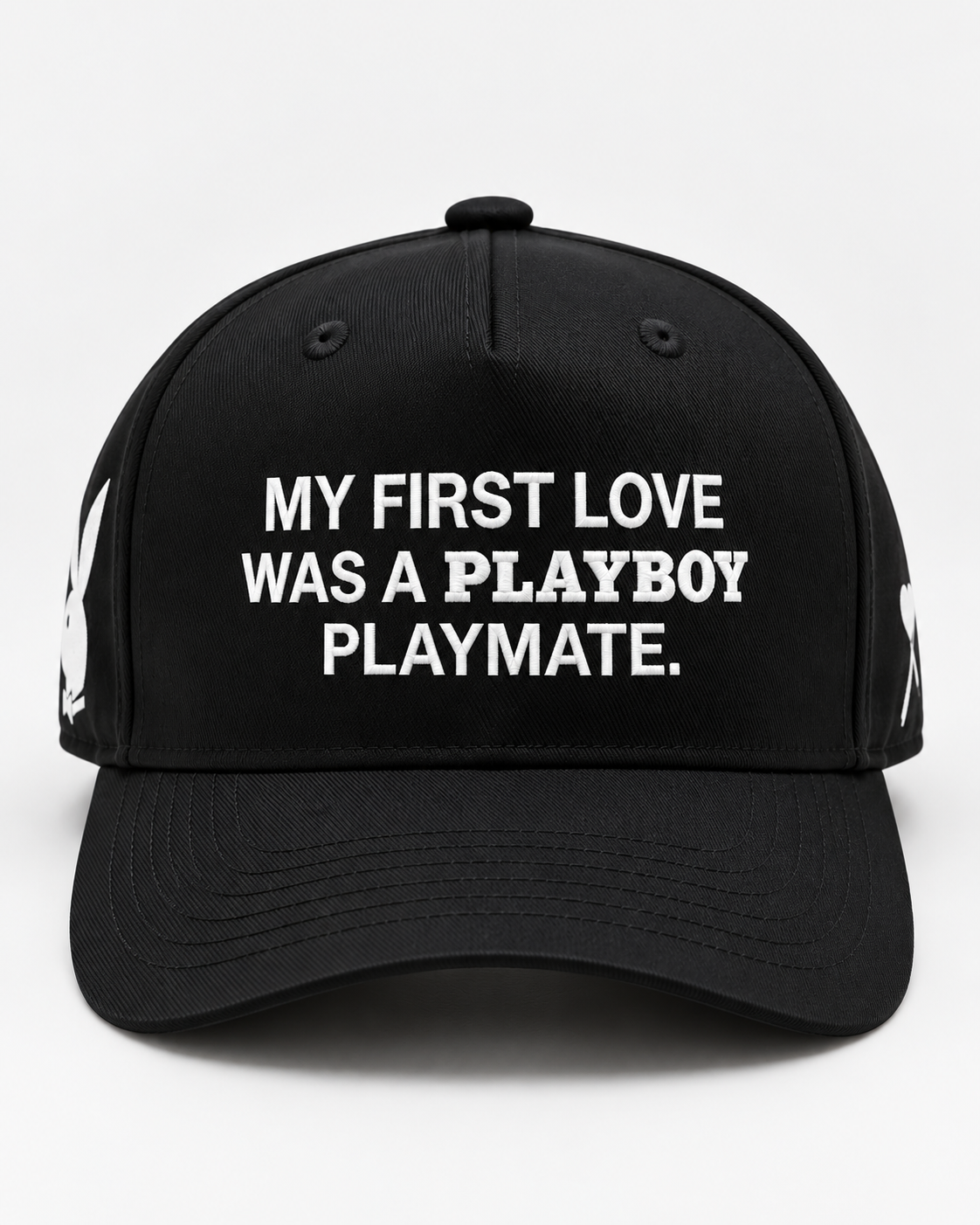 A black baseball cap with white embroidered text reading 'MY FIRST LOVE WAS A PLAYBOY PLAYMATE.' on the front, shown against a plain light background.