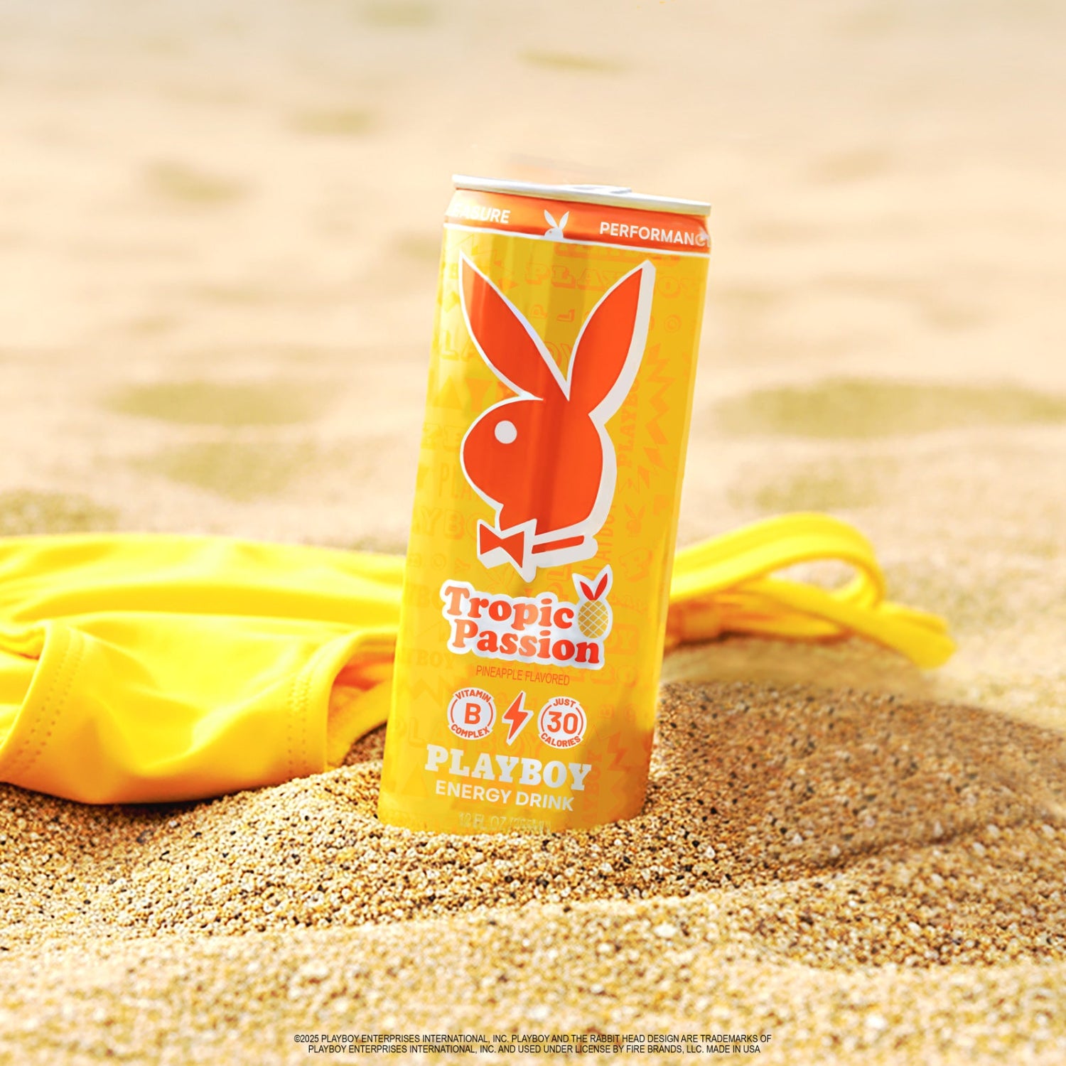 Playboy Tropic Passion energy drink can on sand with yellow towel