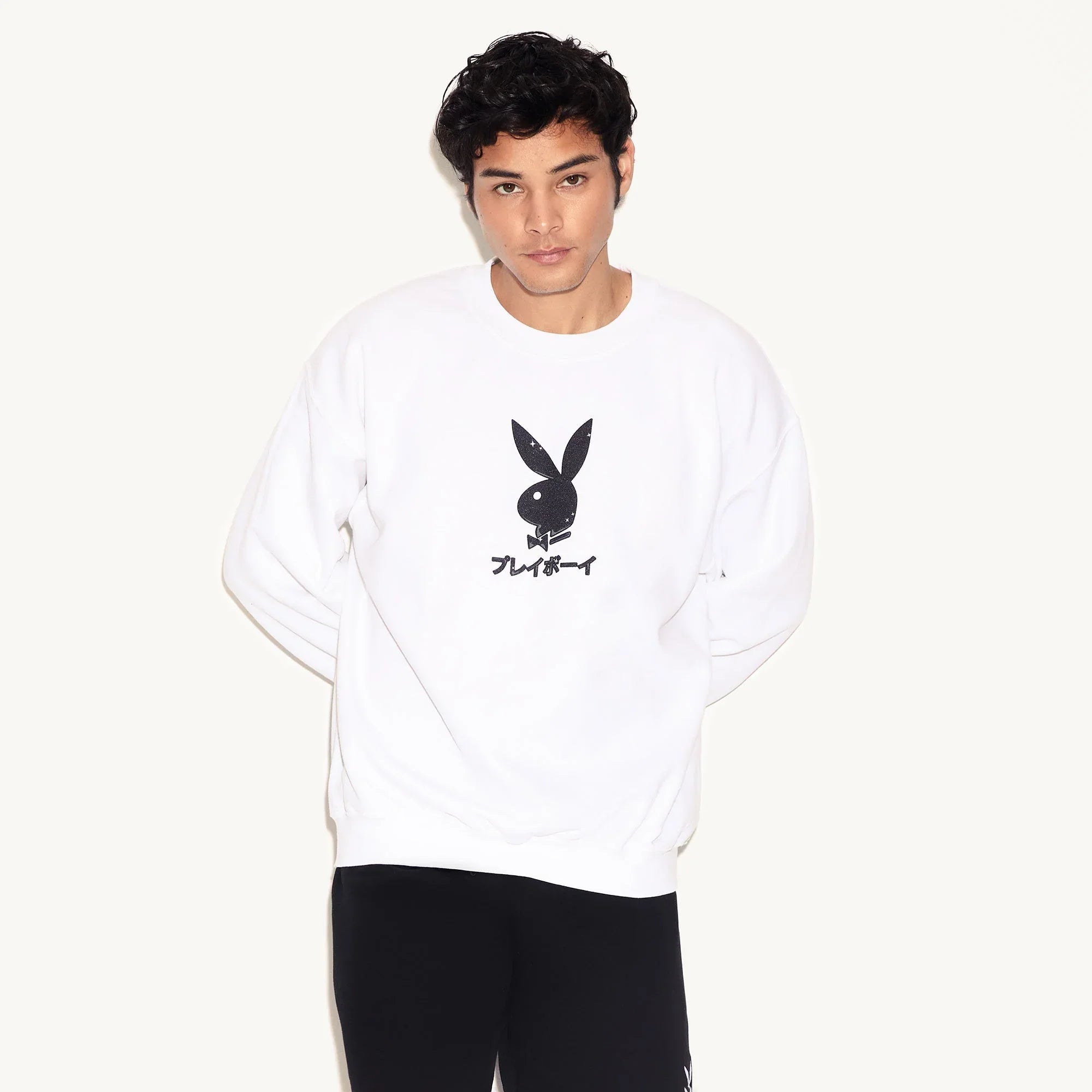 Man wearing white crewneck sweatshirt with black Playboy bunny logo and Japanese text