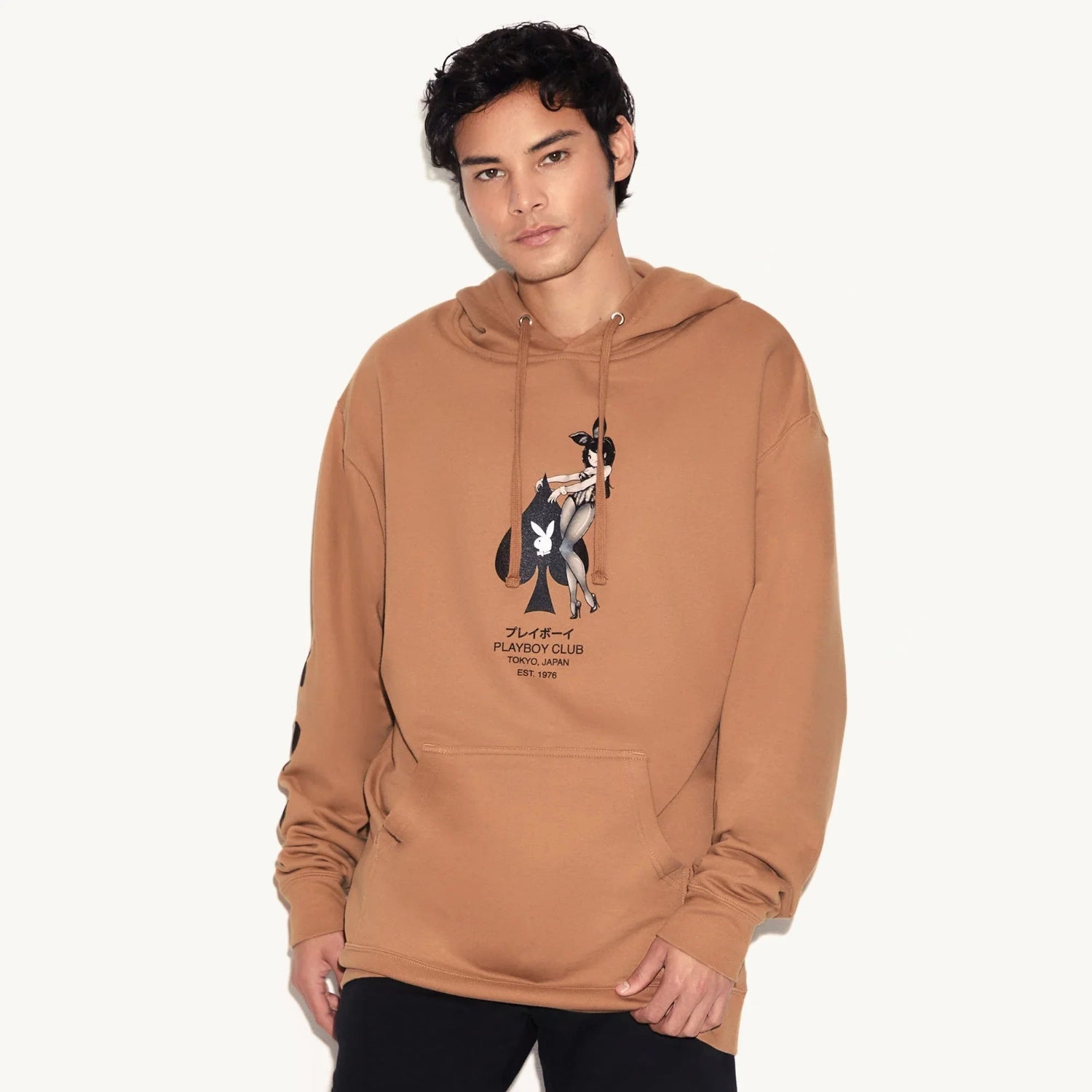 Man wearing tan hoodie with illustrated pin-up girl and Tokyo Japan graphic on front