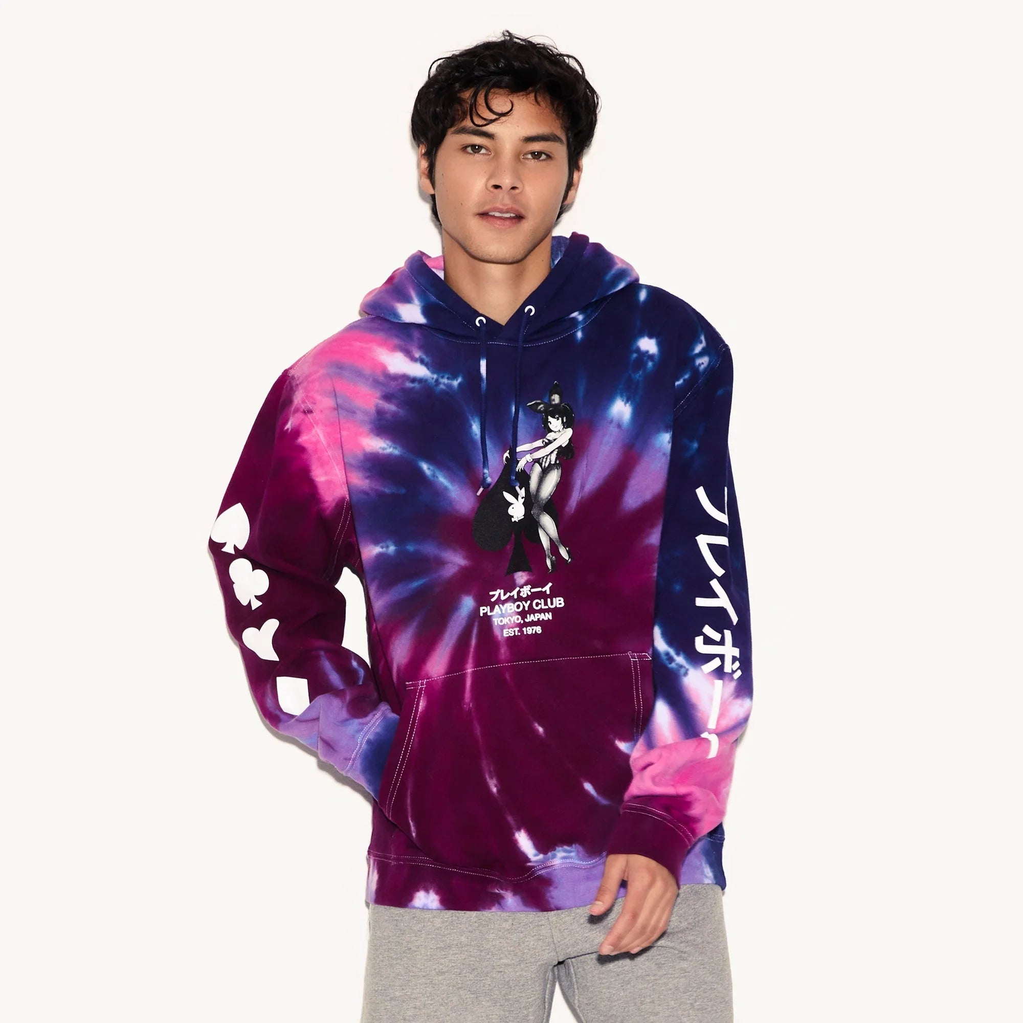 Man wearing purple and blue tie-dye hoodie with graphic print, Japanese text, and card suit symbols.