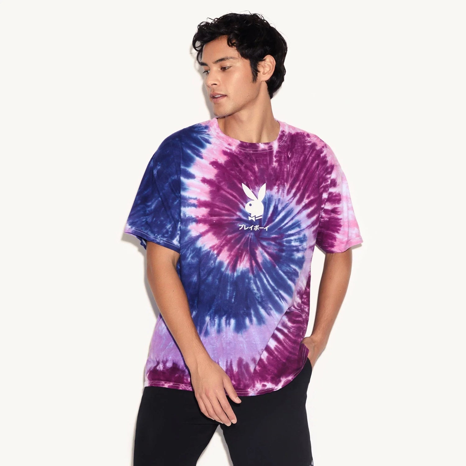 Man wearing a purple and blue tie-dye t-shirt with a white bunny logo on the chest