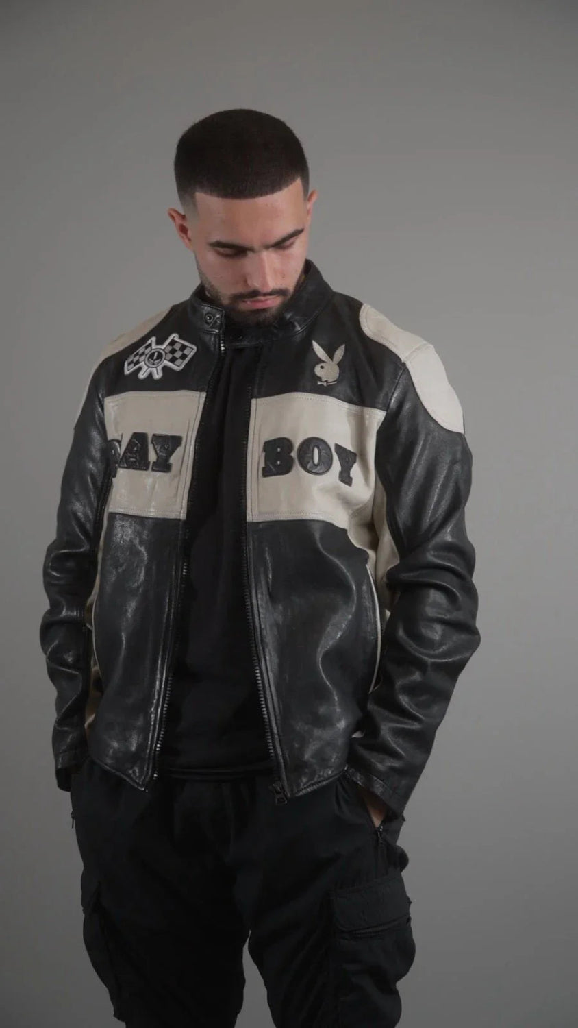 Man wearing black and white leather jacket with bold text patches and graphic logos