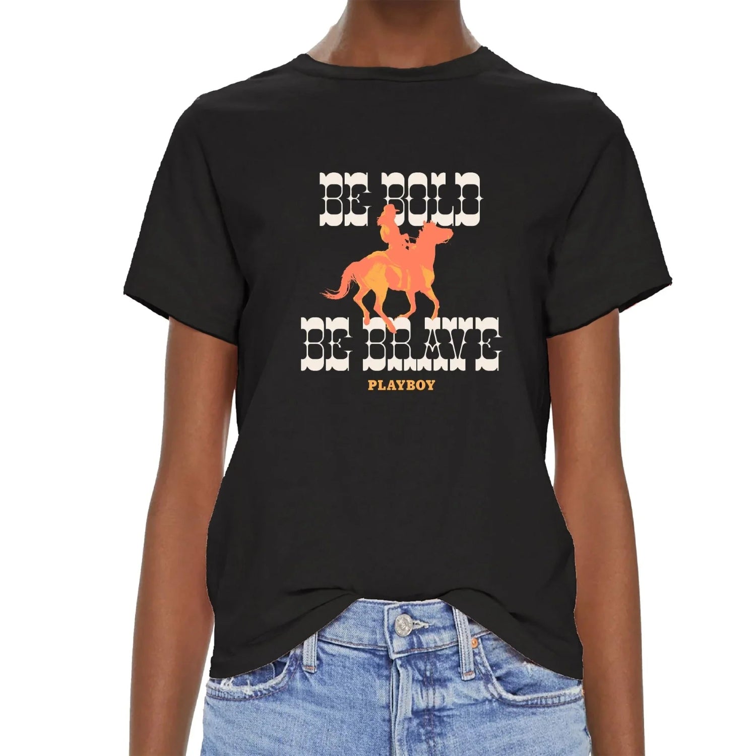 Black graphic western tee with 'Be Bold Be Brave' text, orange cowboy on horse, paired with jeans.