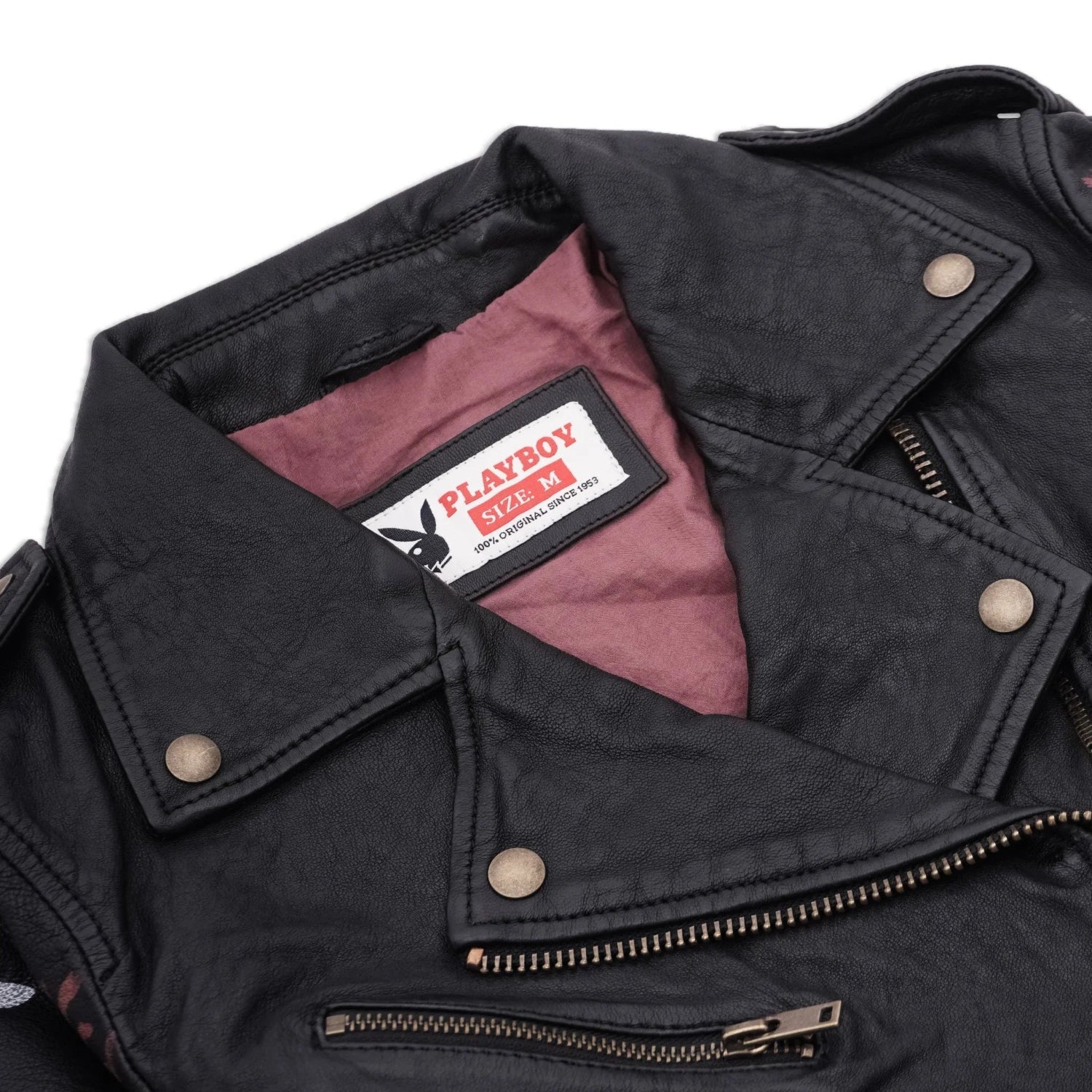 Close-up of a women’s black leather jacket with zippers and a visible label inside