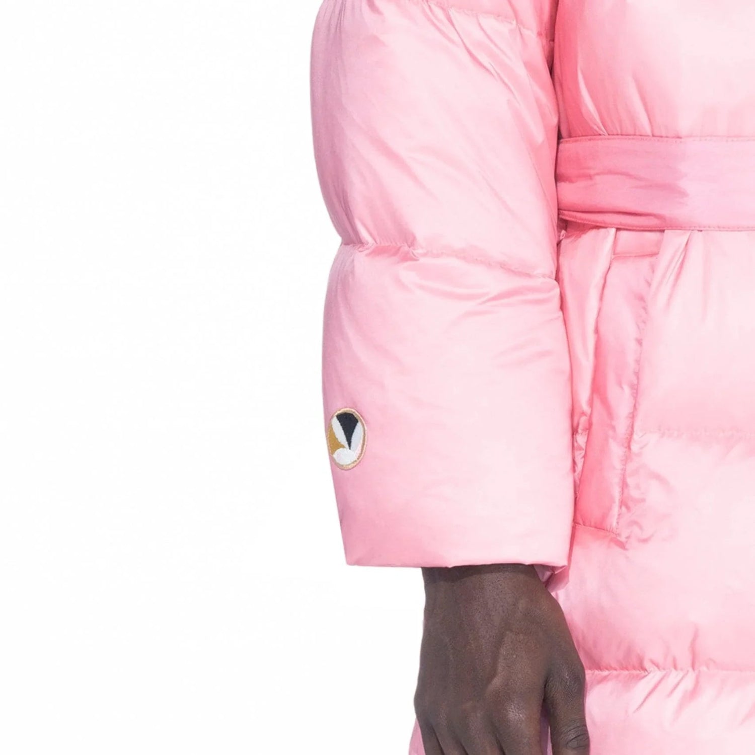 Pink belted long puffer jacket with sleeve patch, close-up on arm and waist