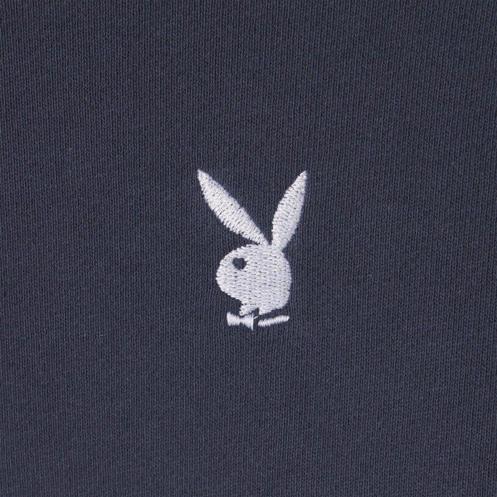 Close-up of white bunny head logo embroidered on black ribbed crewneck sweatshirt fabric