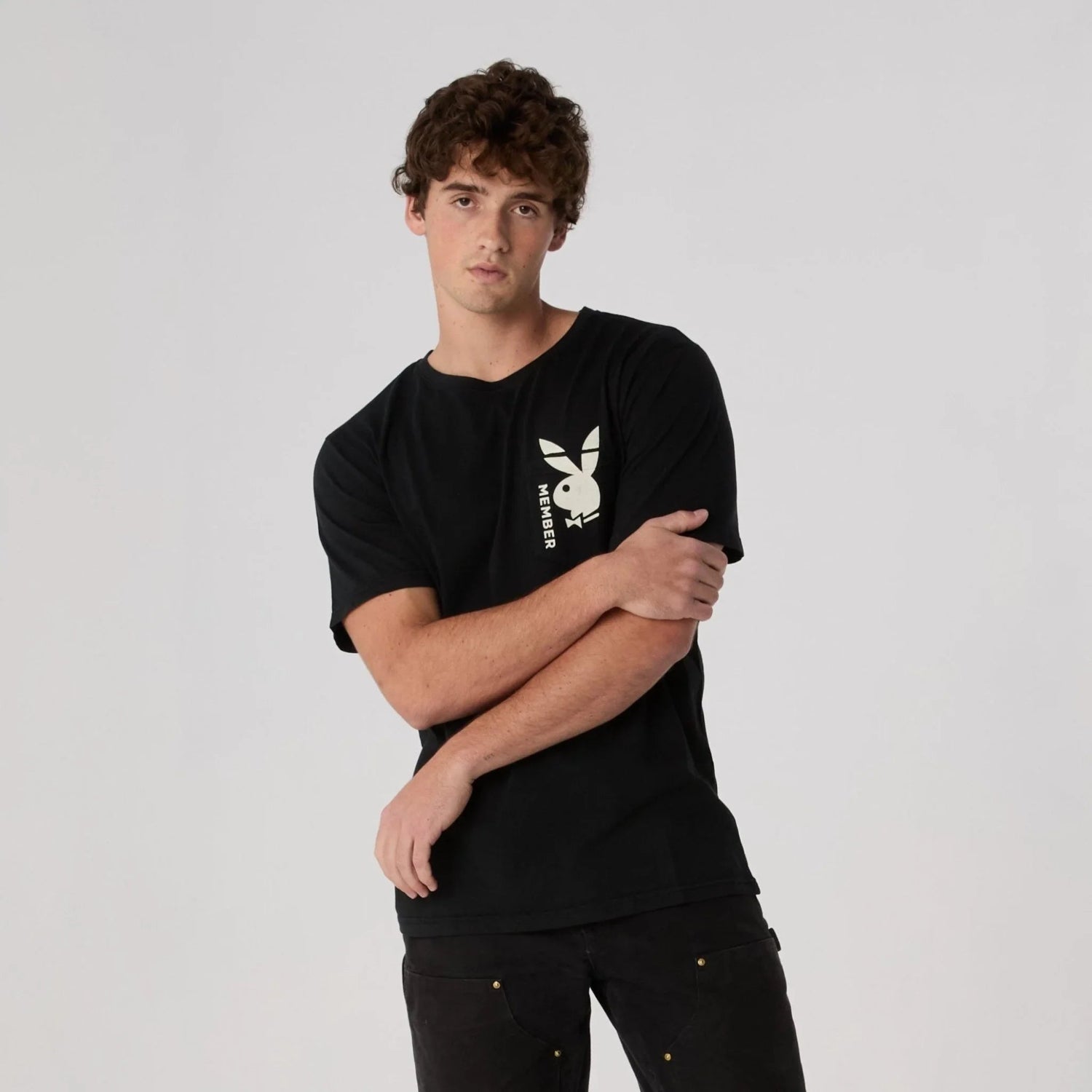 Man wearing black pocket tee with white bunny logo and 'MEMBER' text on chest