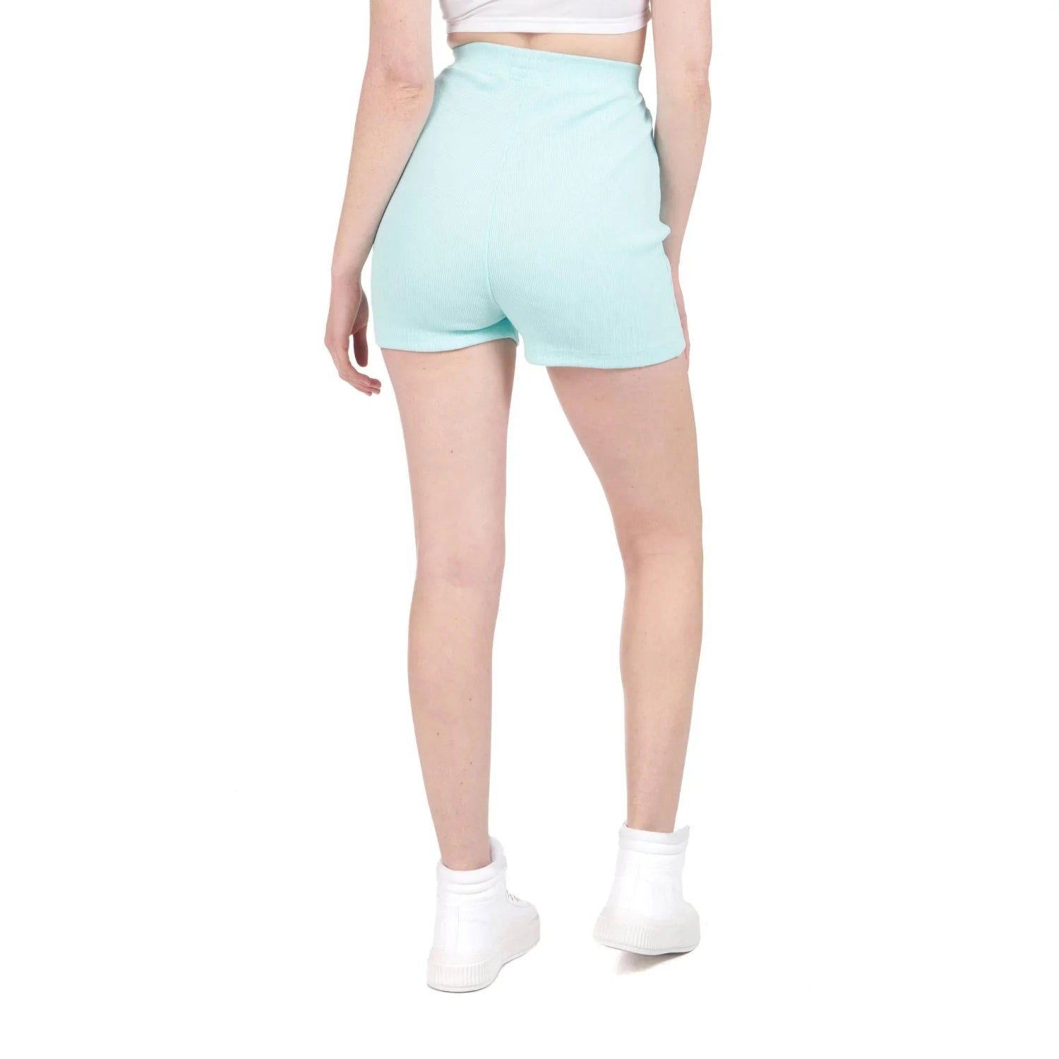 Woman wearing light blue high-waisted biking shorts and white sneakers, back view