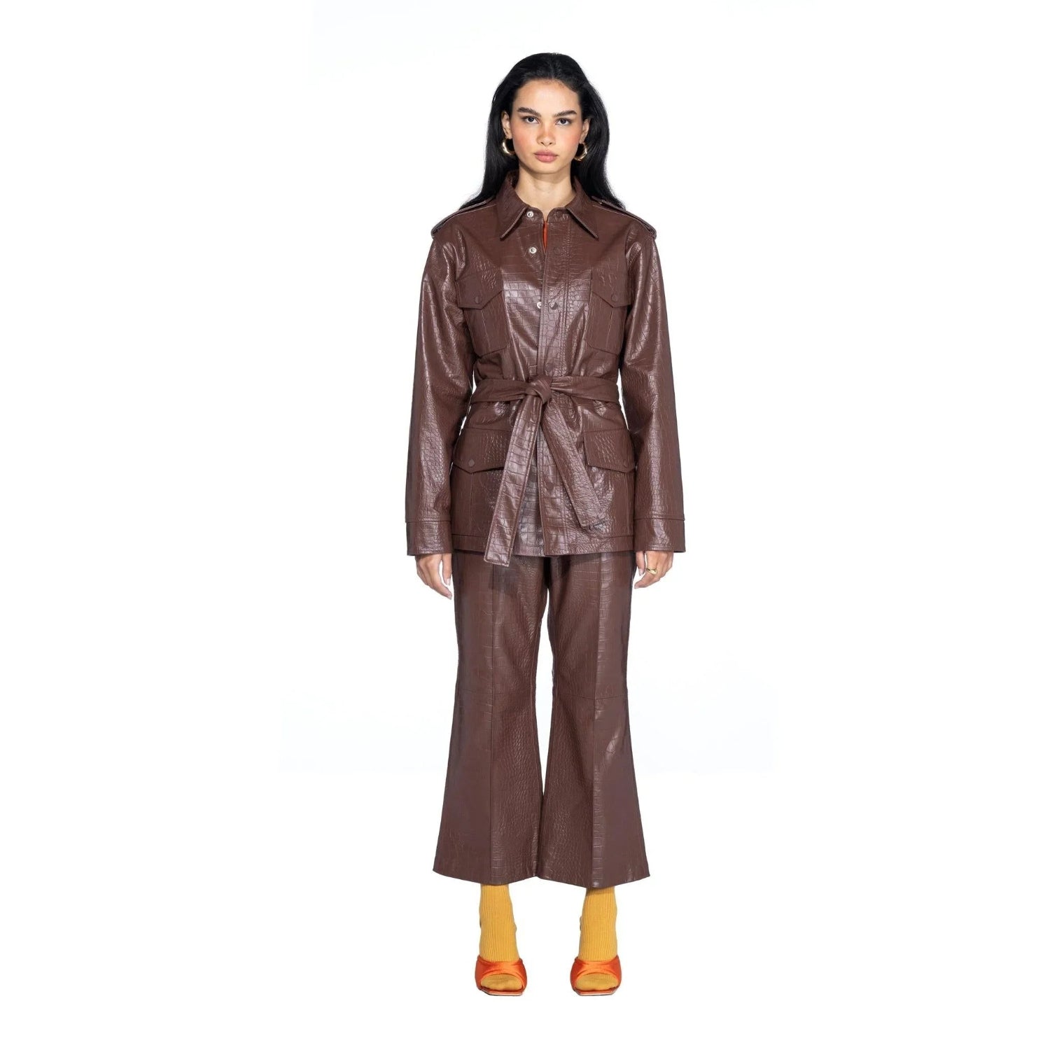 Woman wearing brown crocodile-embossed leather safari jacket and matching pants