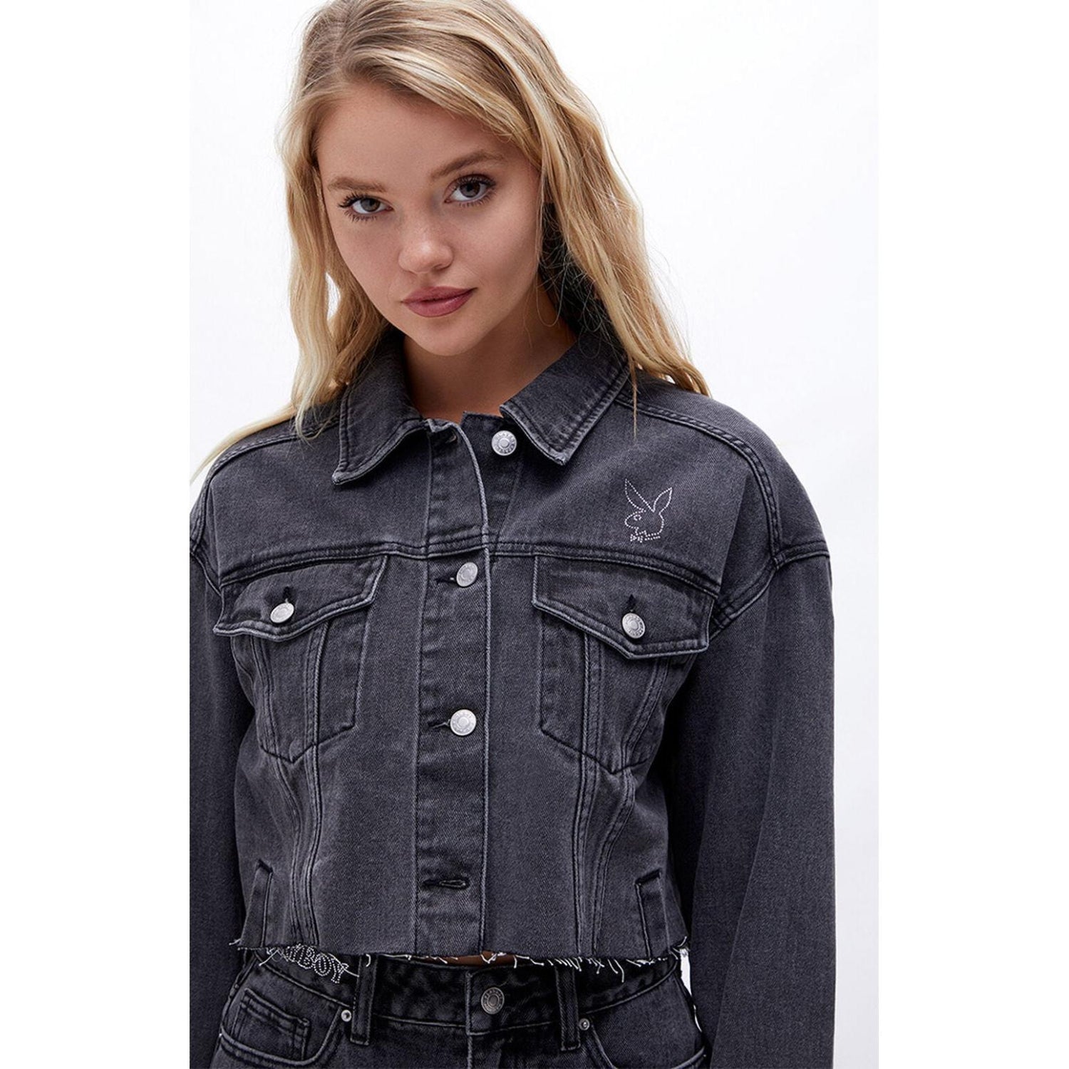 Woman wearing black denim cropped jacket with embroidered bunny logo on chest