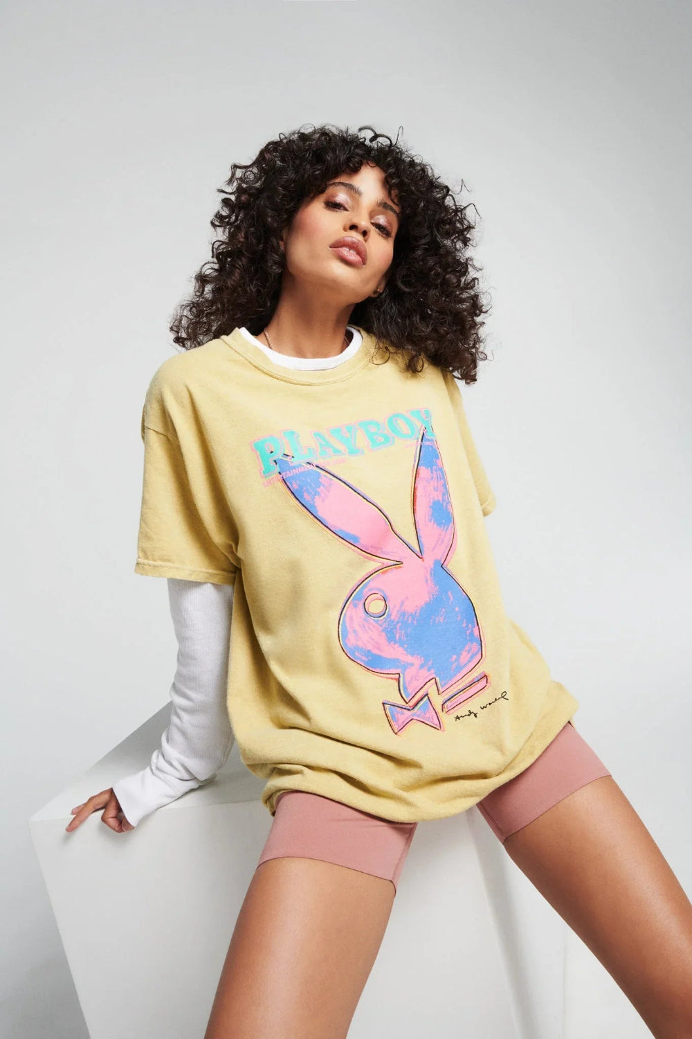 Woman wearing yellow t-shirt with retro pop art bunny graphic and pink bike shorts