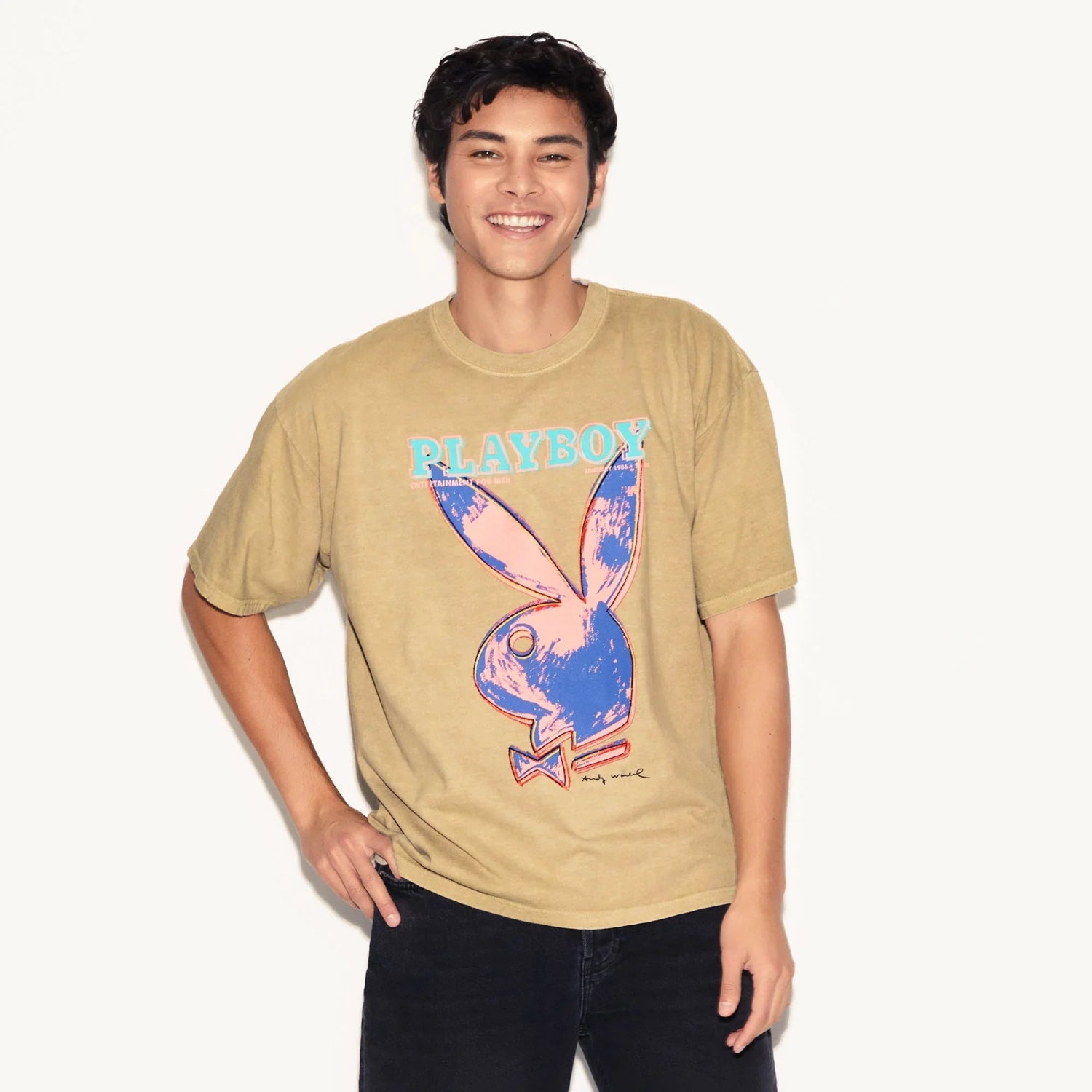 Man wearing tan t-shirt featuring pop art bunny graphic and bold PLAYBOY text