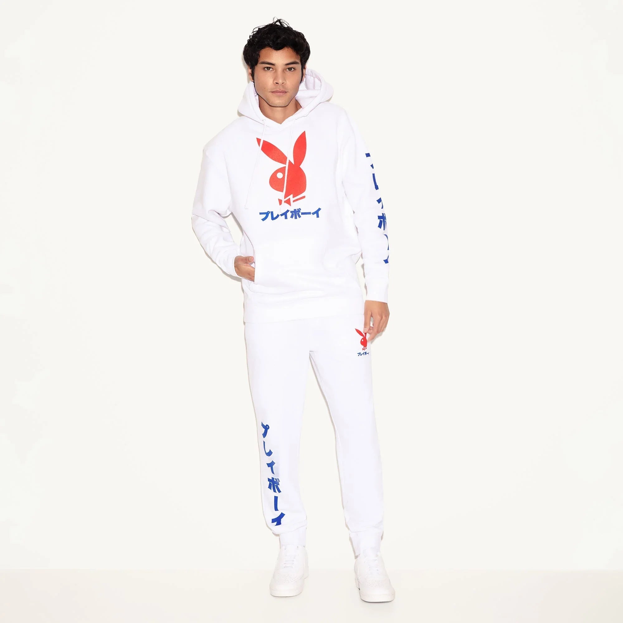 Man wearing white hoodie and joggers with bold red rabbit head graphic and blue Japanese text