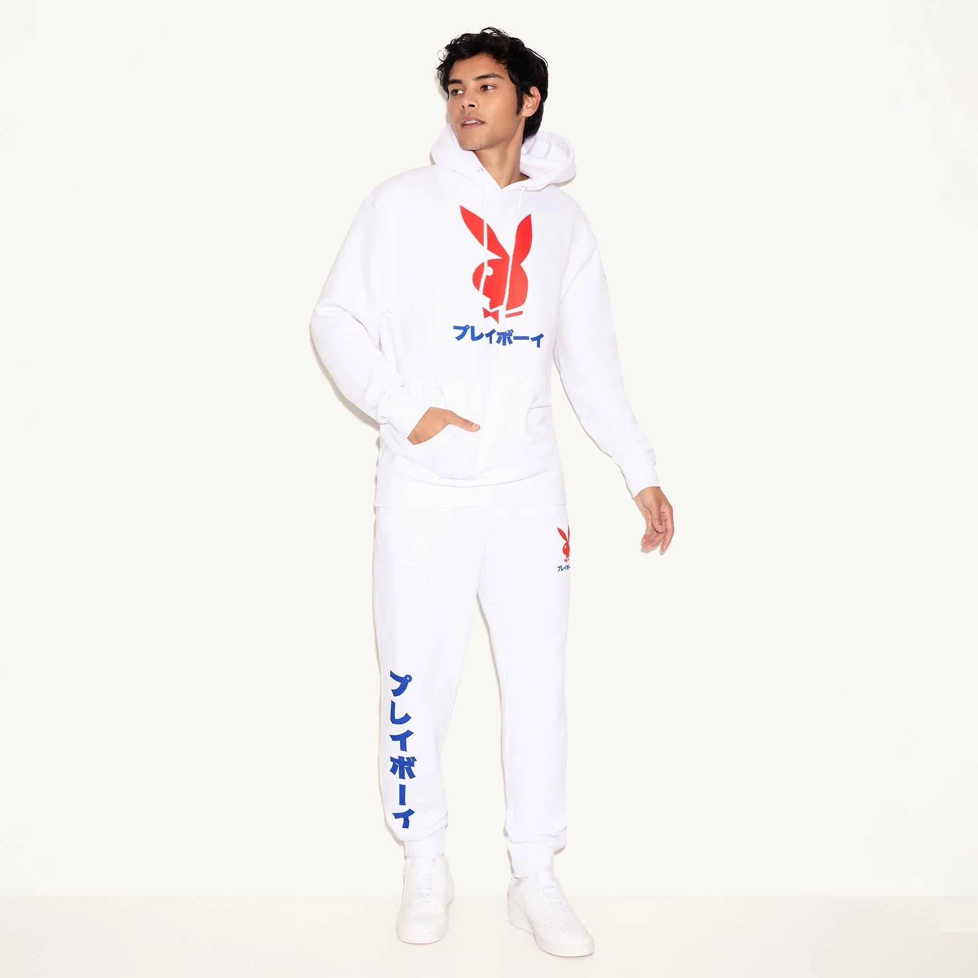Man wearing white hoodie and joggers with red rabbit head and Japanese text graphics
