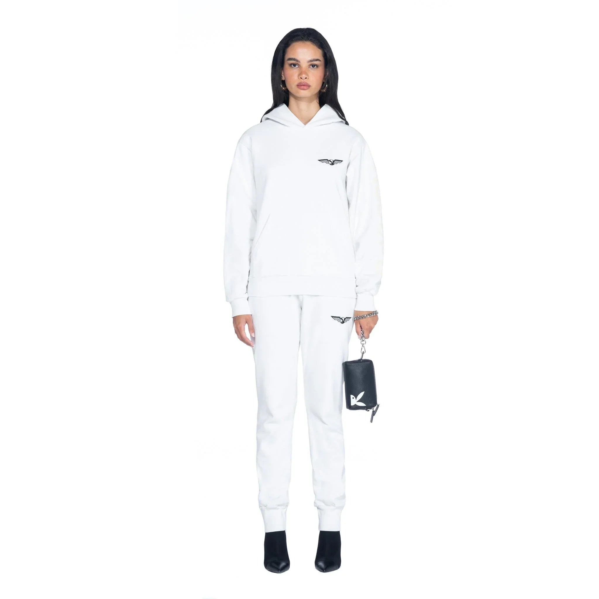 Woman in white hoodie and joggers holding black leather pouchette with white bunny logo