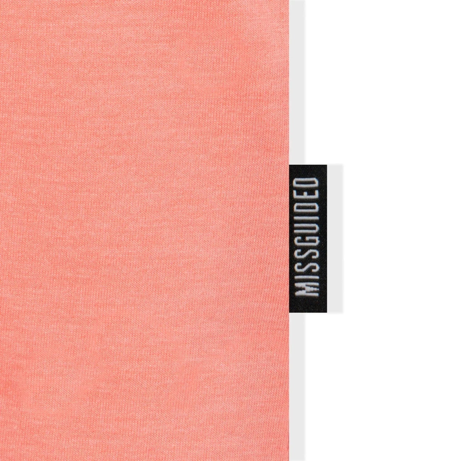 Close-up of a peach oversized t-shirt fabric and MISSGUIDED label tag