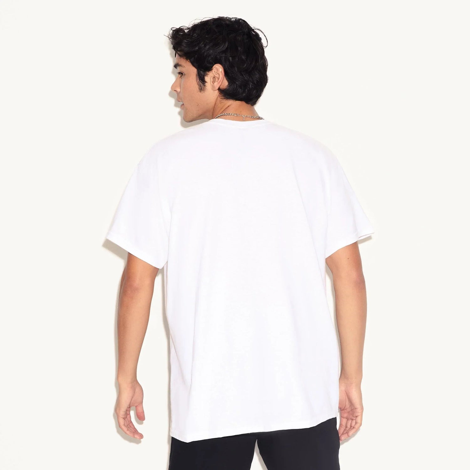 Man wearing plain white short-sleeve t-shirt, shown from the back, on white background