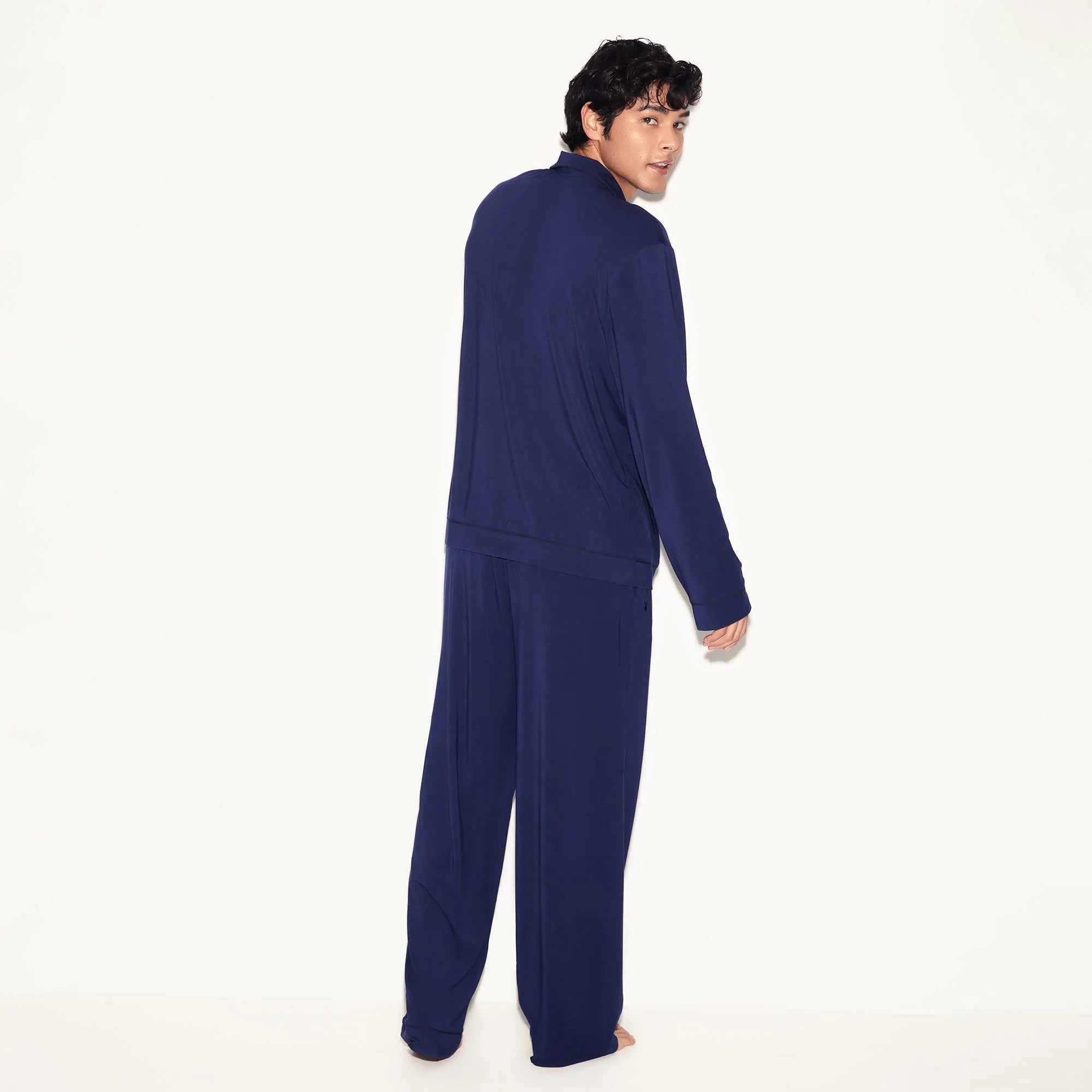 Man wearing navy blue men's classic sleep set, long sleeve pajama top and pants, back view