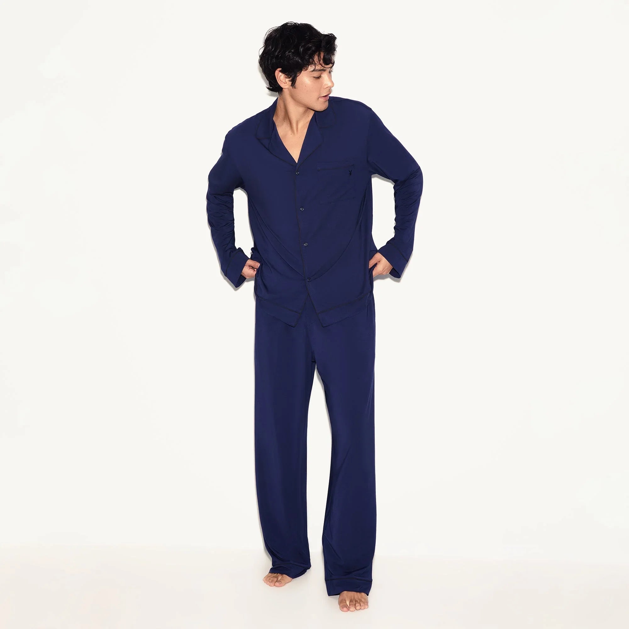 Man wearing a classic navy blue men's sleep set with button-up shirt and pants