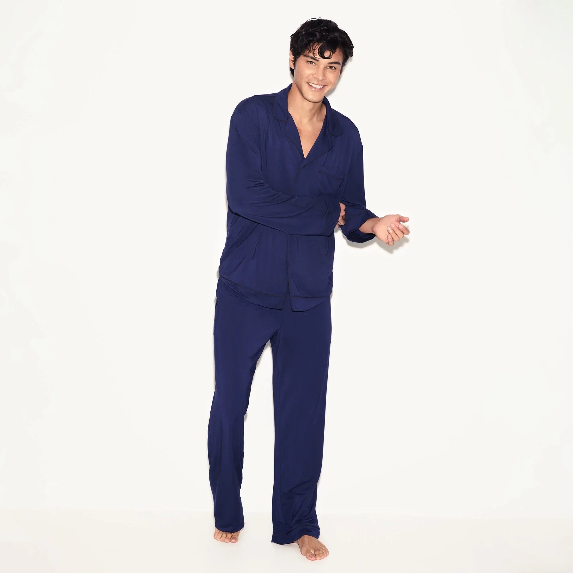Man wearing navy blue classic men's sleep set with long sleeve top and pants on white background