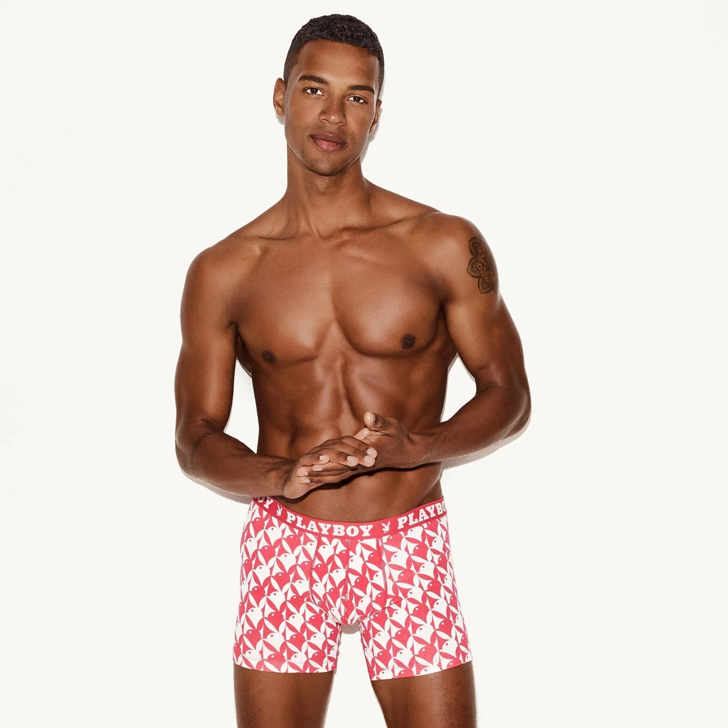 Man modeling red and white men's boxer briefs with graphic logo waistband on white background