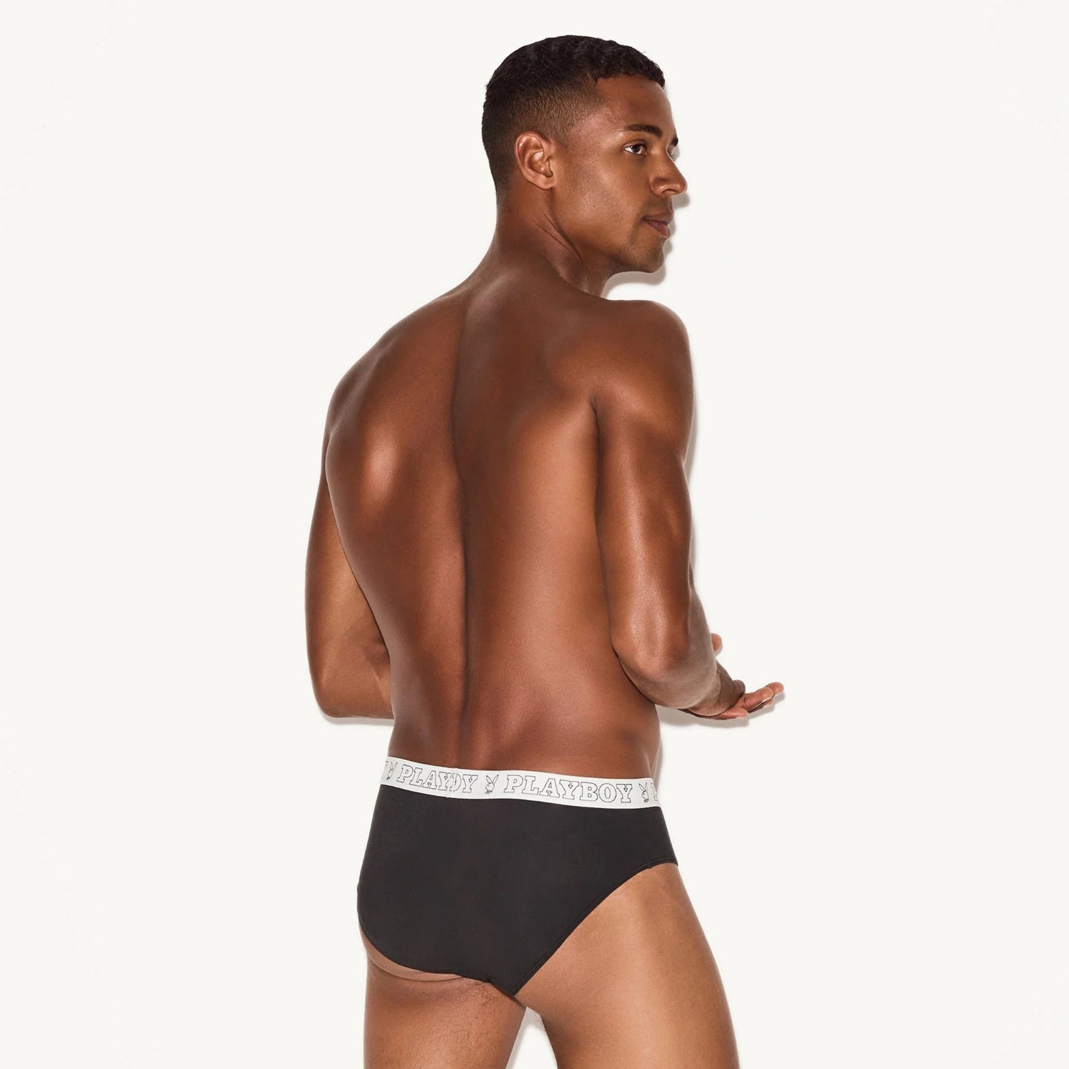 Male model wearing black modal briefs with branded elastic waistband on white background
