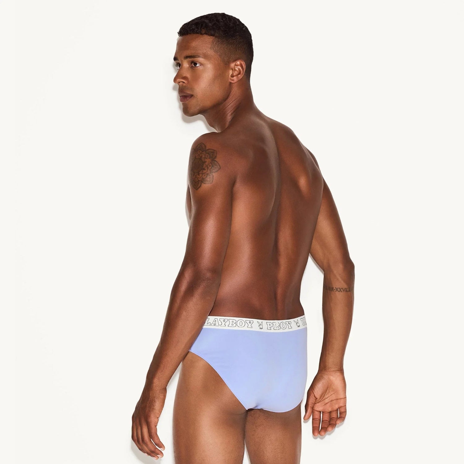 Male model wearing light blue men's modal briefs with white logo waistband, back view