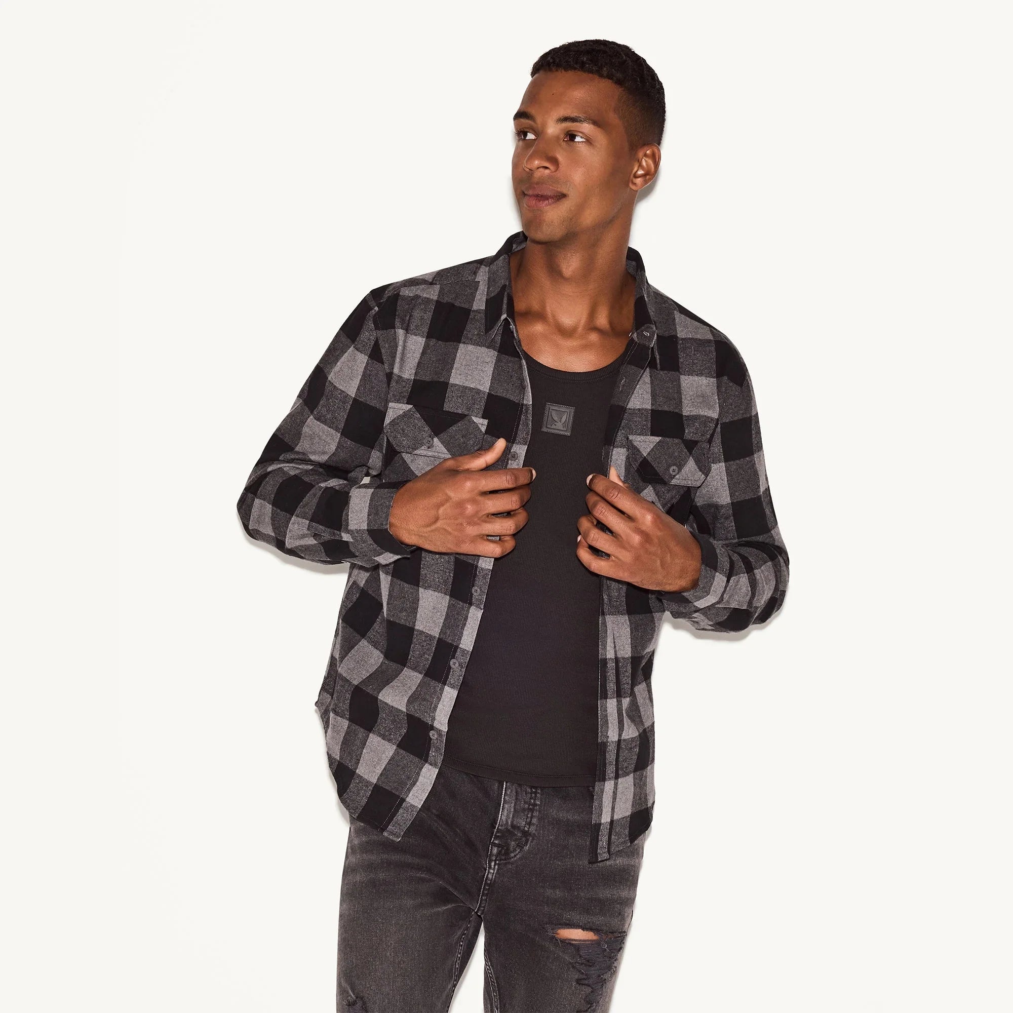 Man wearing black and gray plaid flannel long sleeve shirt and black jeans