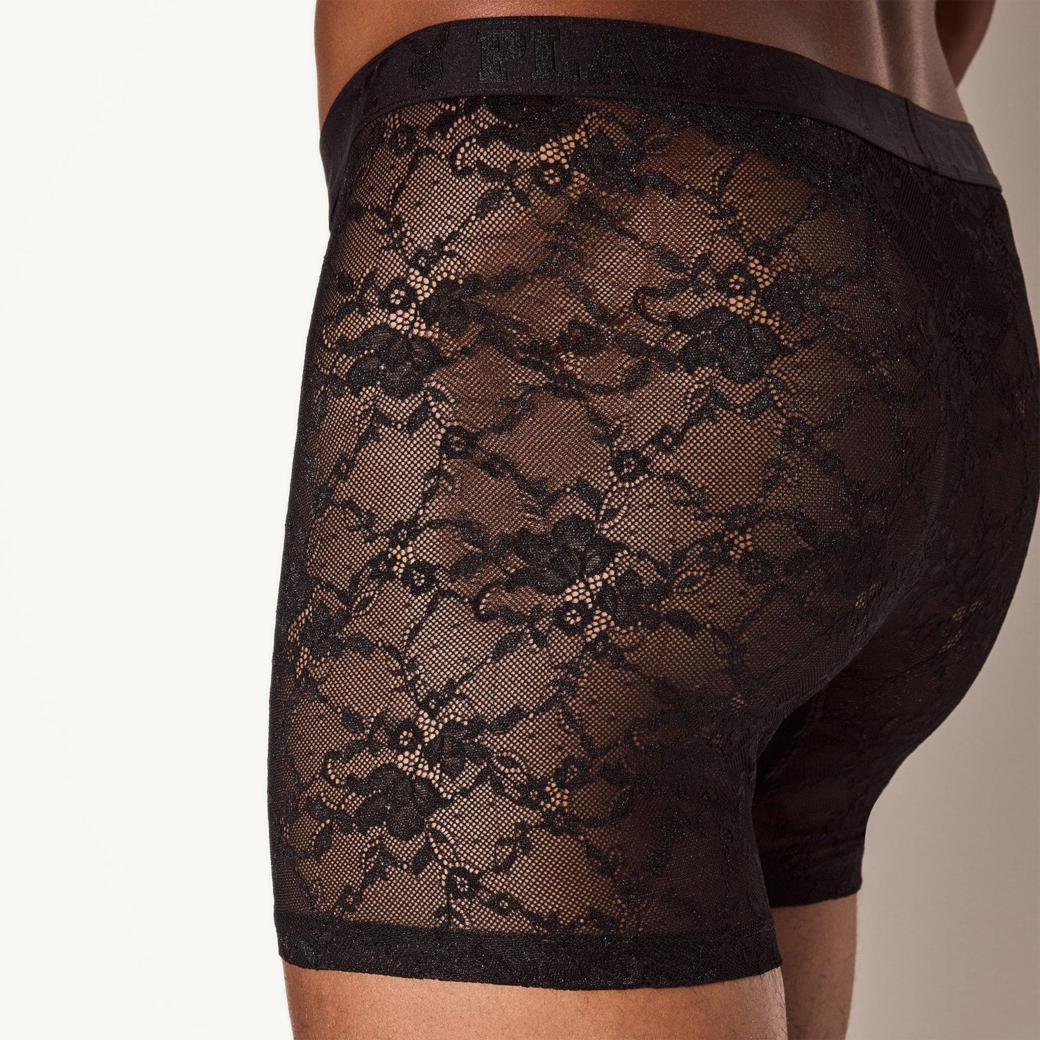 Men's sheer black lace boxer briefs with floral pattern, close-up rear view
