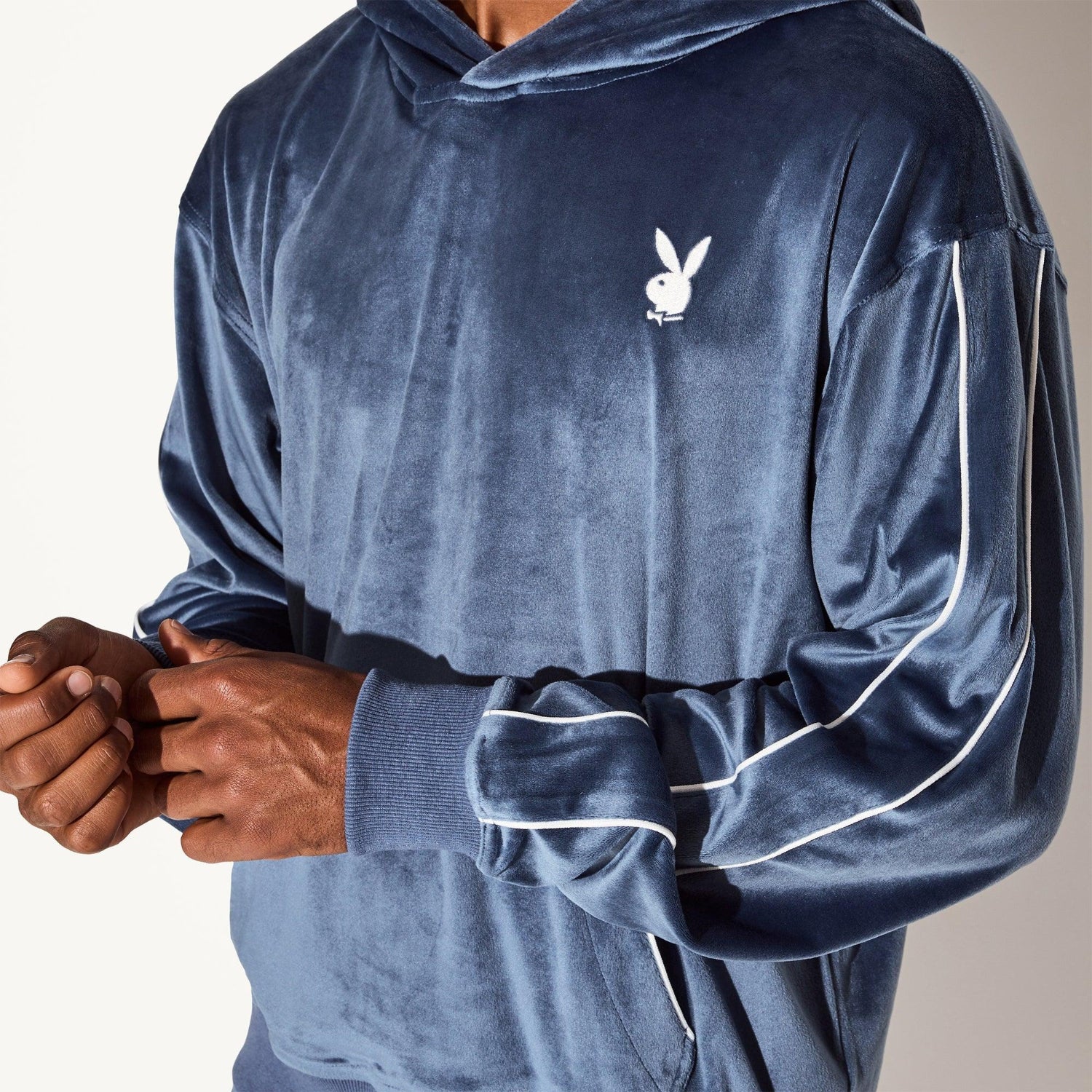 Men's blue velour hoodie with white rabbit head logo and white piping on sleeves