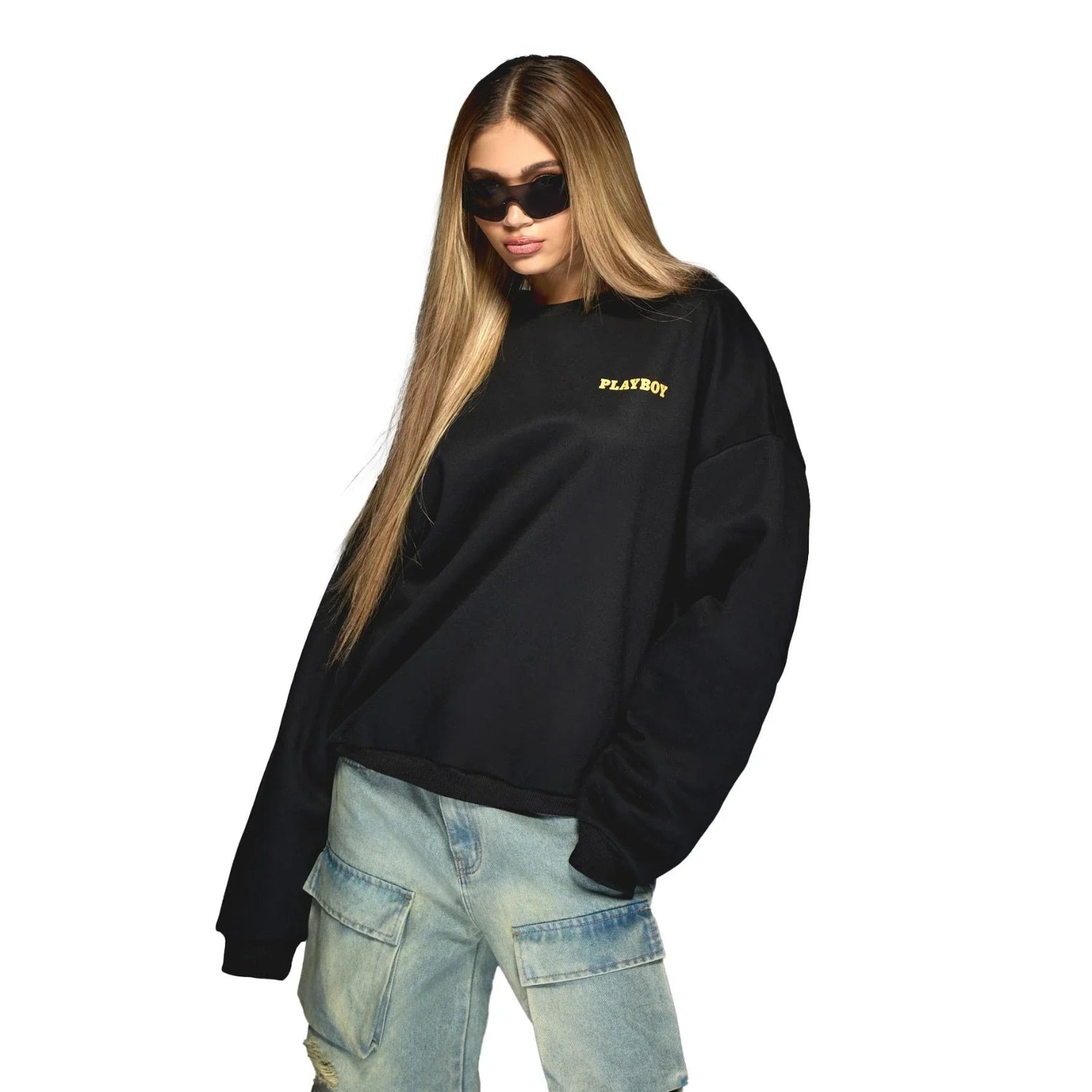 Woman in black Playboy logo sweatshirt and blue cargo jeans, wearing sunglasses