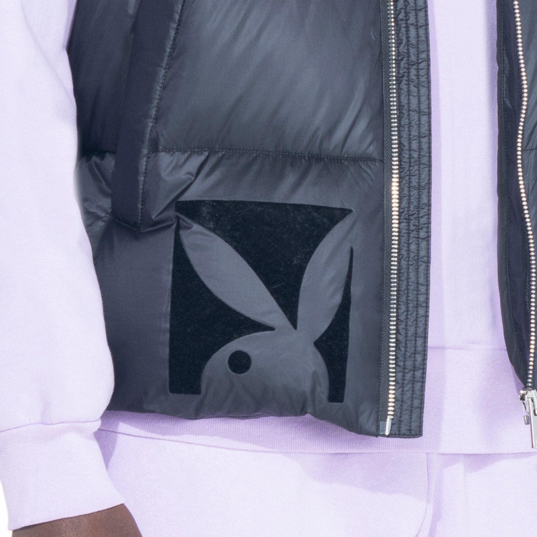 Black puffer vest with large bunny logo patch, worn over lavender sweatshirt and pants