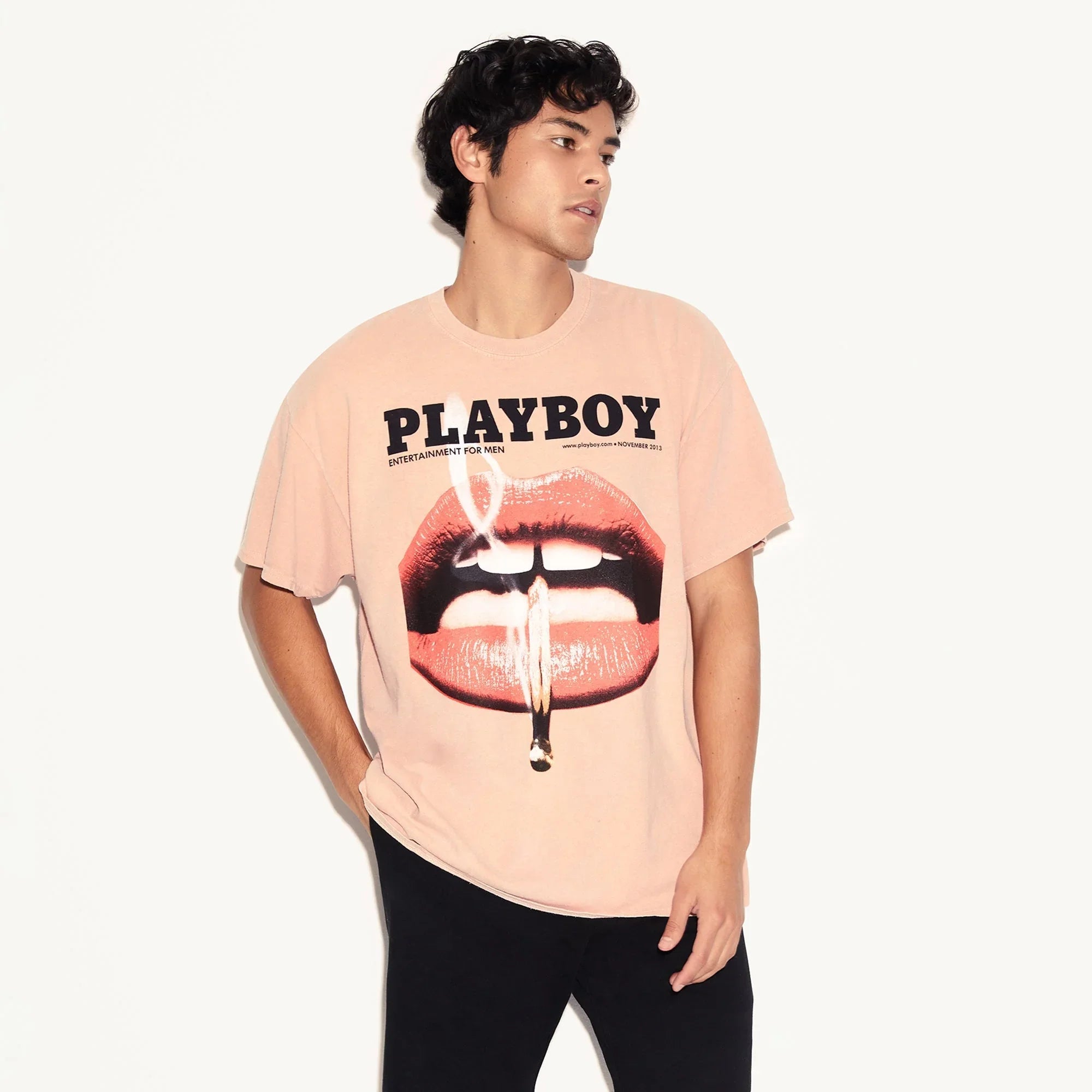 Man wearing graphic Playboy t-shirt with large lips print and casual black pants