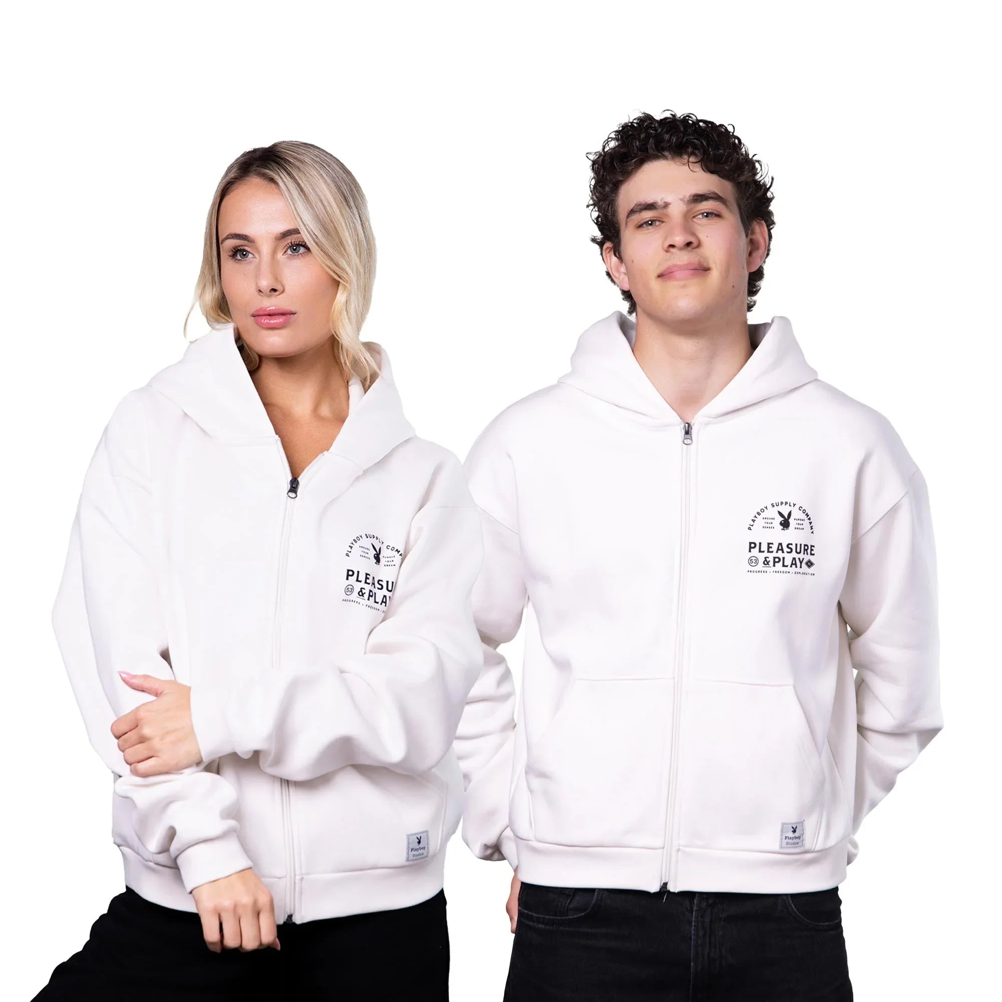 Two models wearing white zip-up hoodies with 'Pleasure & Play' graphic on chest.