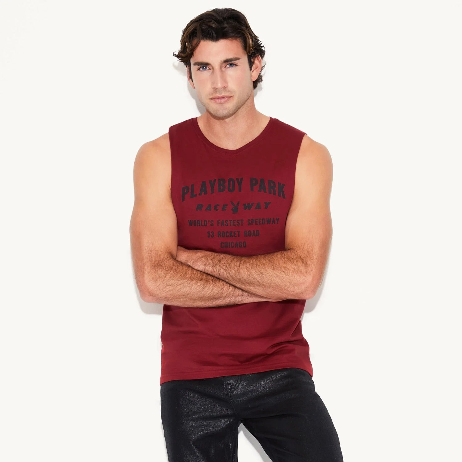 Man wearing a sleeveless red muscle tank top with 'Playboy Park Raceway' graphic, plain background
