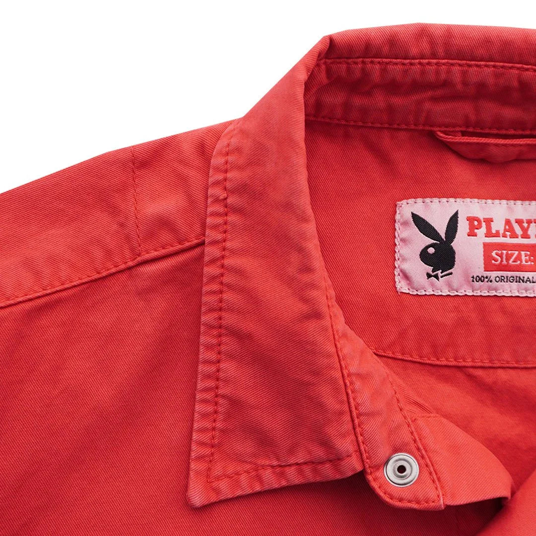 Close-up of red button-up shirt with collar and black bunny logo label on inside neck