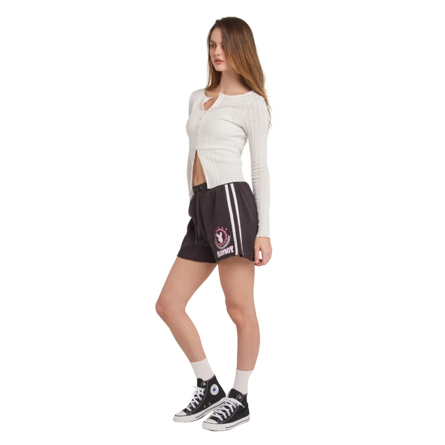 Woman wearing black varsity shorts with white stripes and graphic print, casual outfit