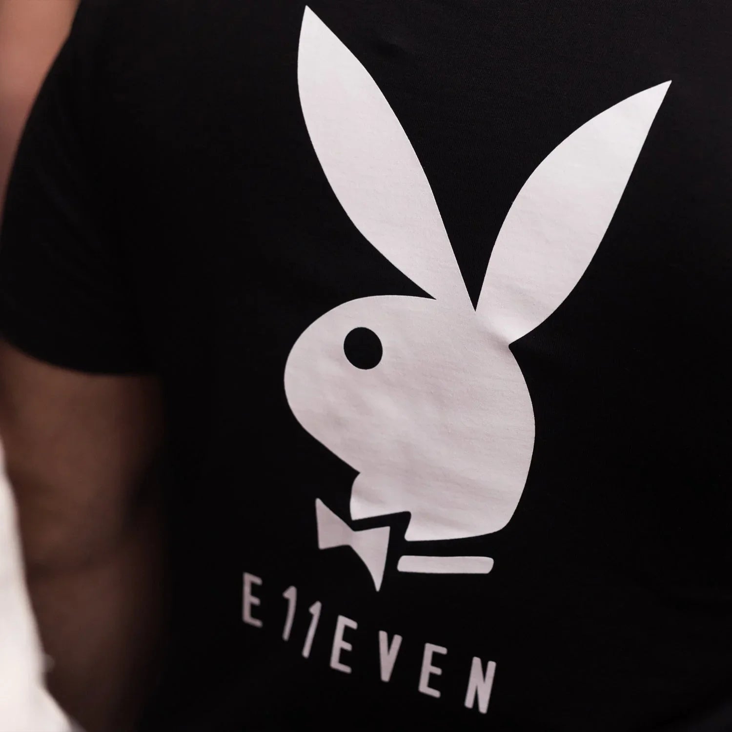 Black t-shirt featuring large white bunny head and bowtie graphic with E11EVEN text below.