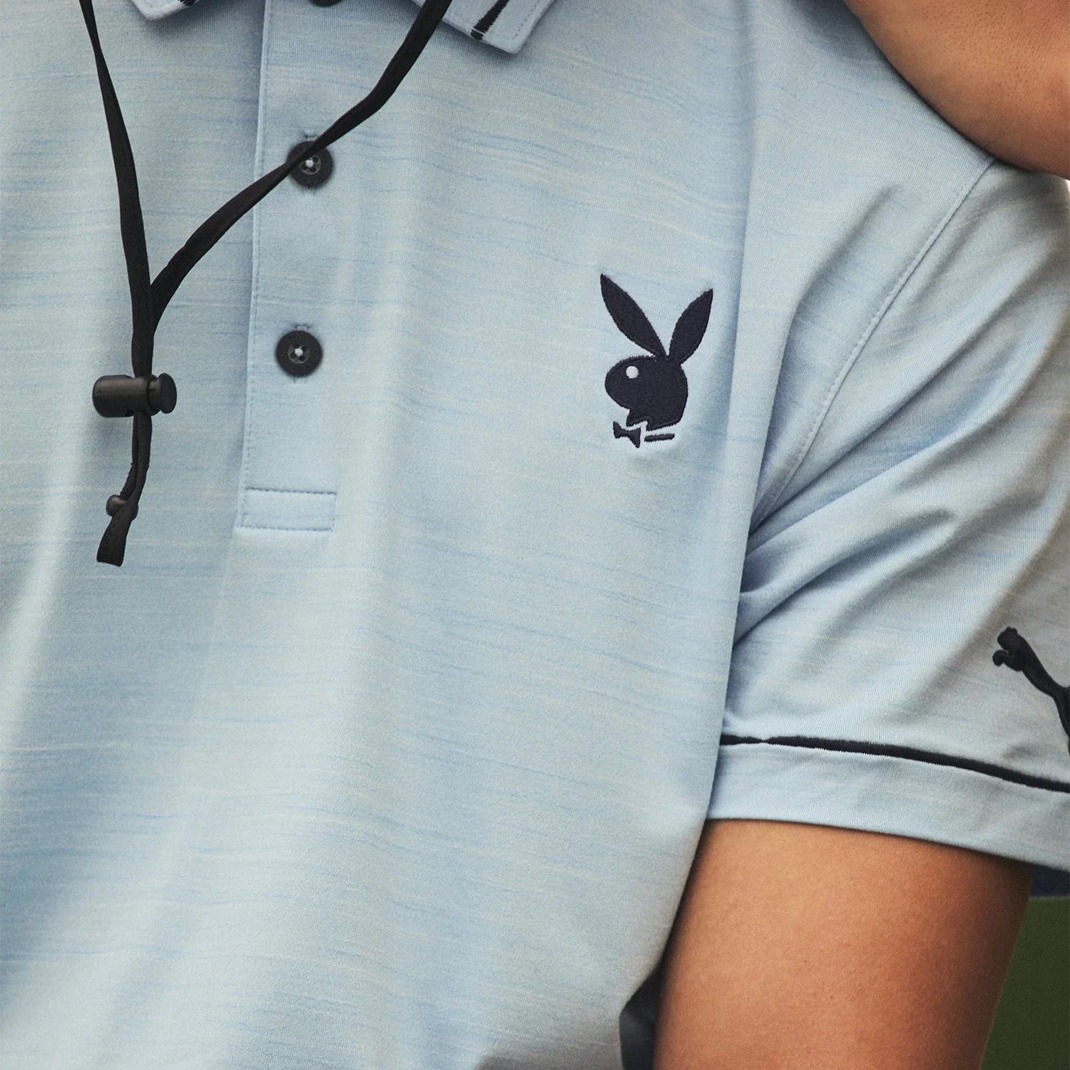 Light blue men's polo shirt with Playboy bunny logo on chest and Puma logo on sleeve