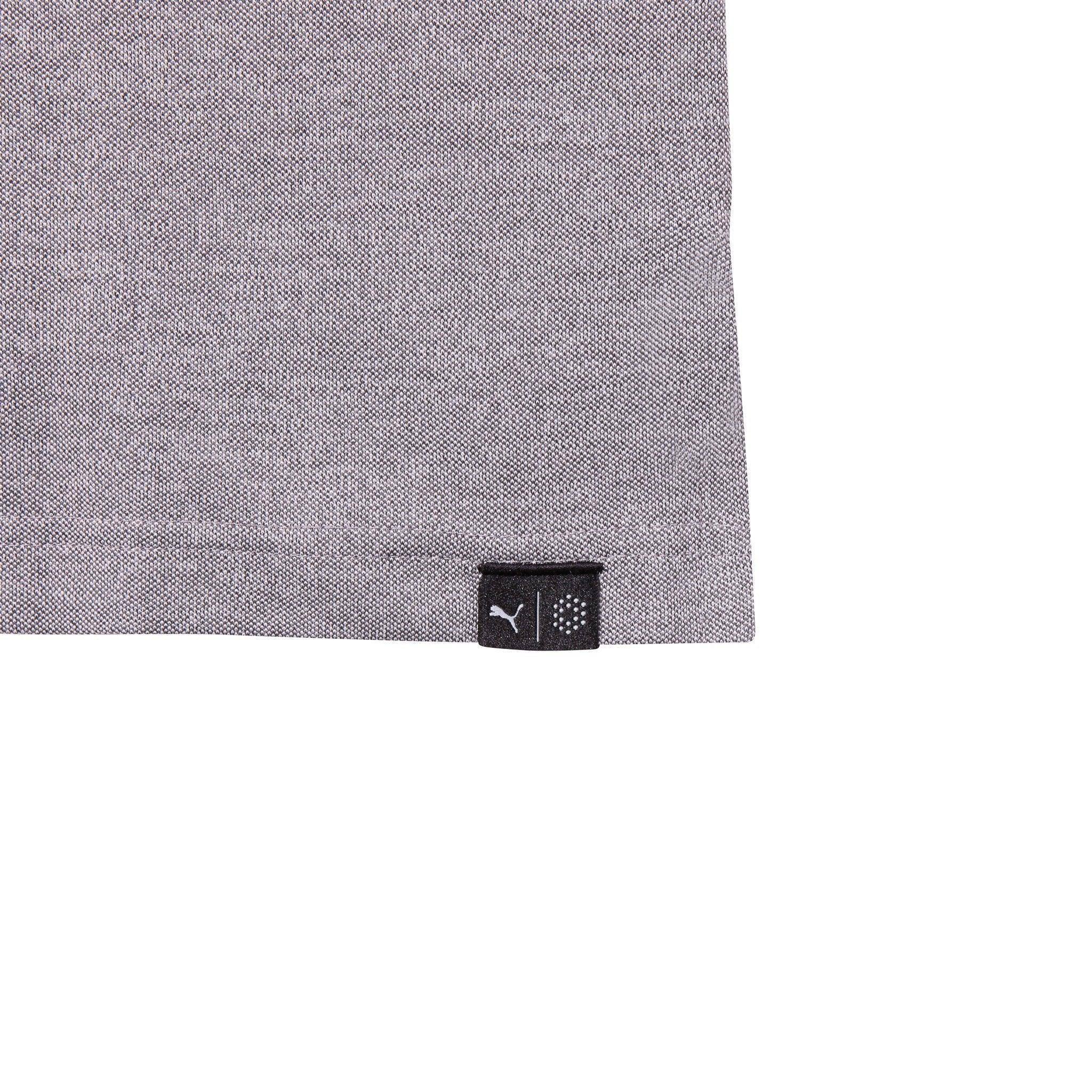 Close-up of grey performance polo shirt hem with small black logo tag