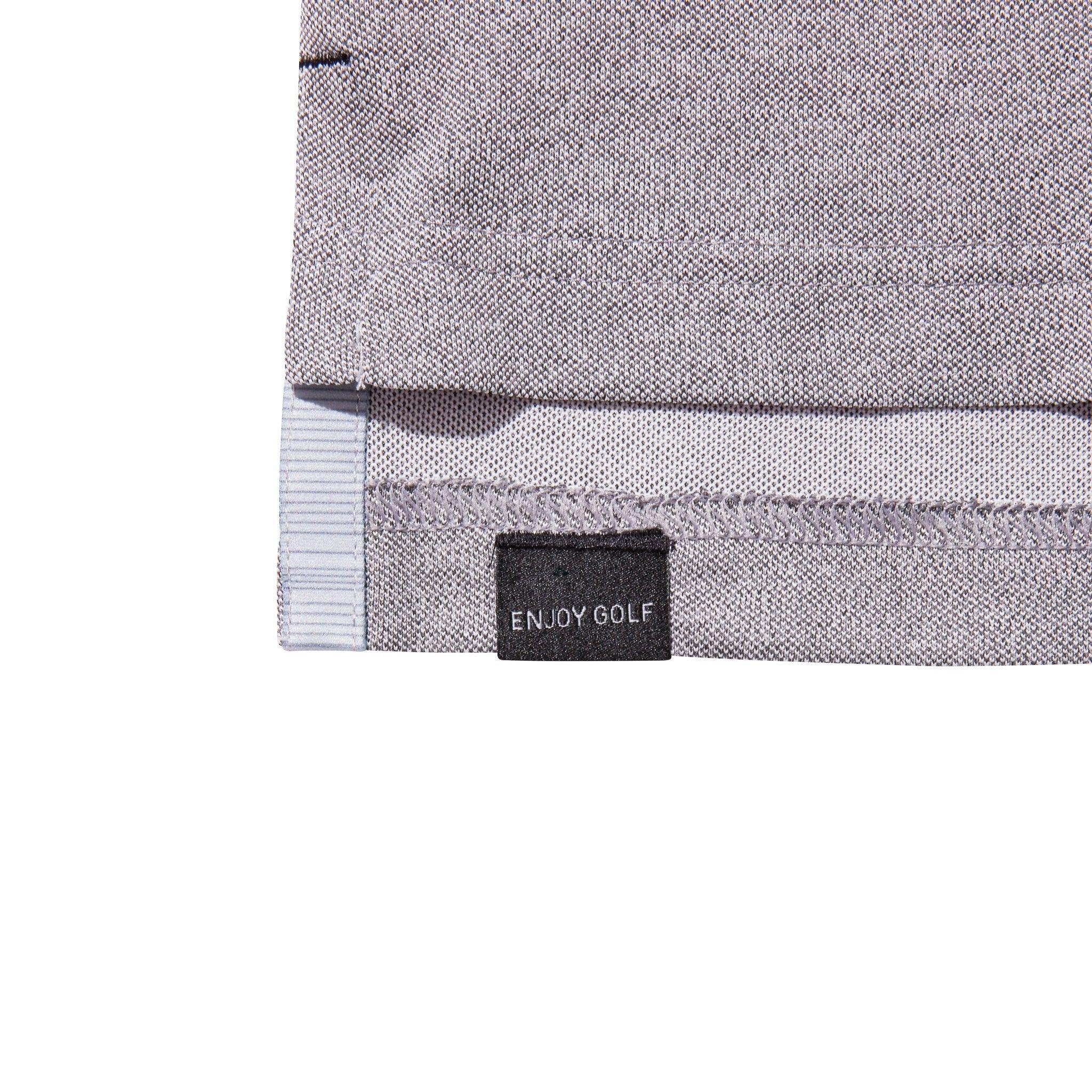 Closeup of light grey golf polo shirt hem with 'Enjoy Golf' label tag